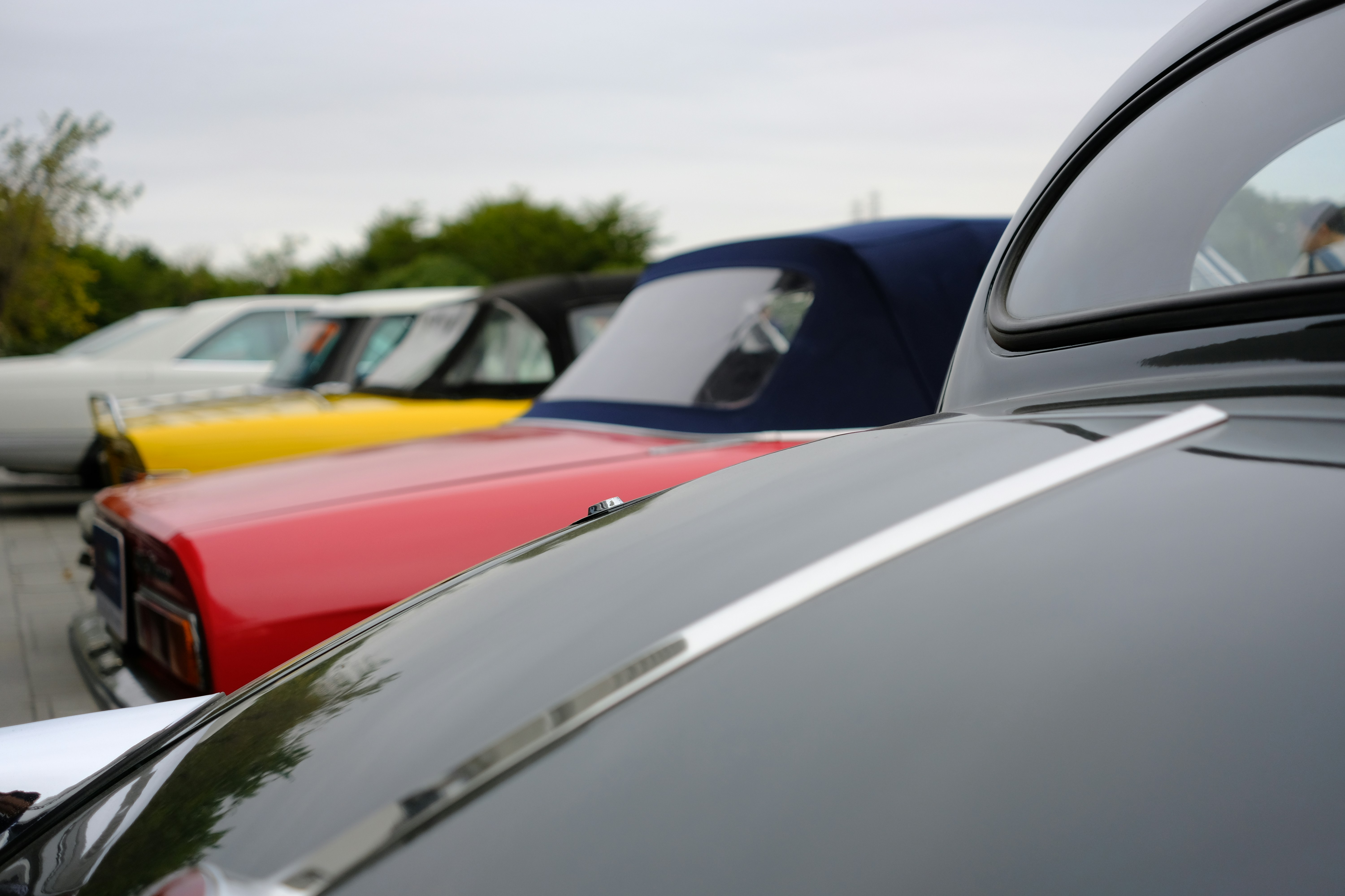 Row of vintage cars with colorful hoods