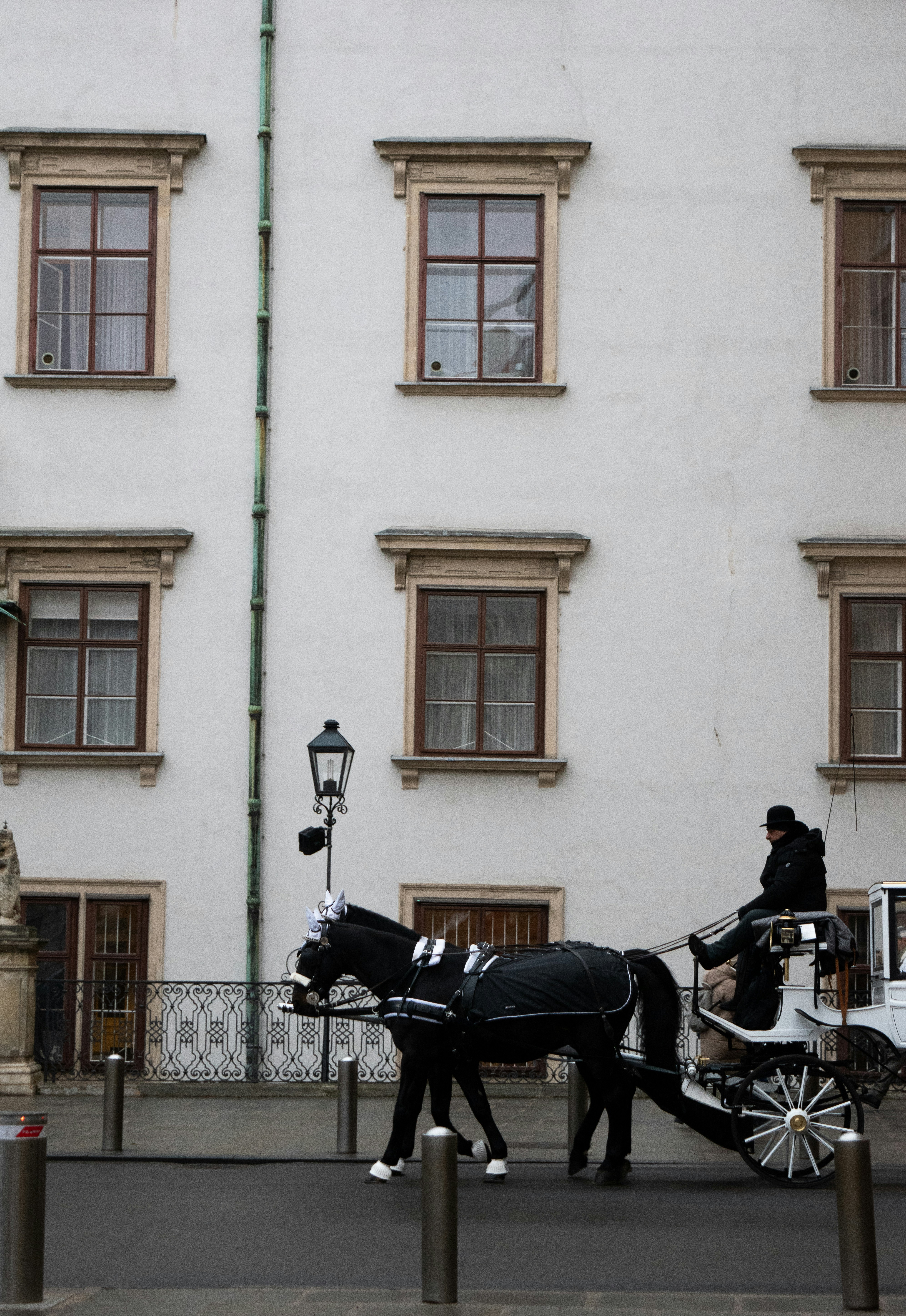 Un carruaje tirado por caballos pasa junto a un edificio
