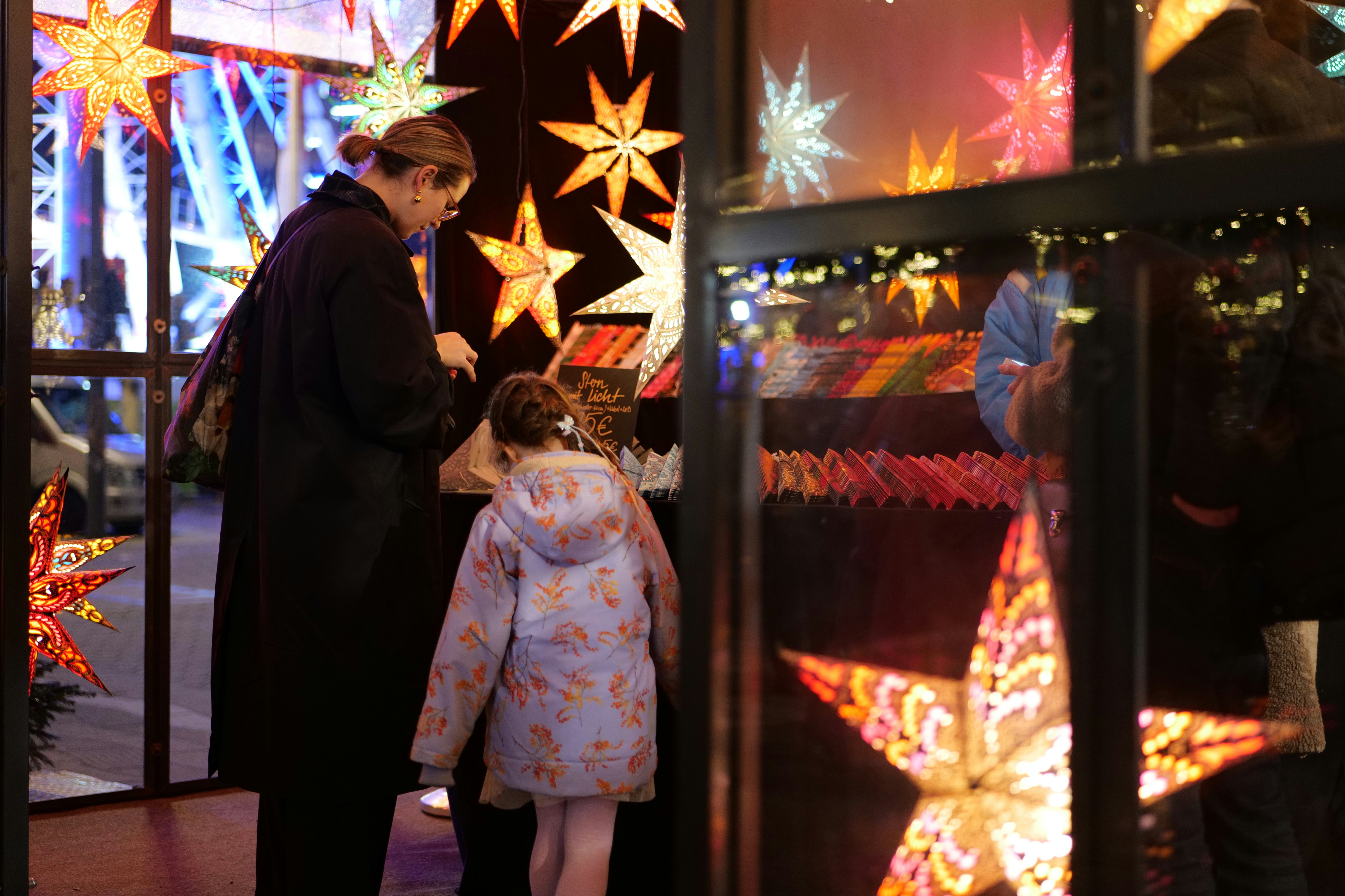People looking at festive star lights at night.
