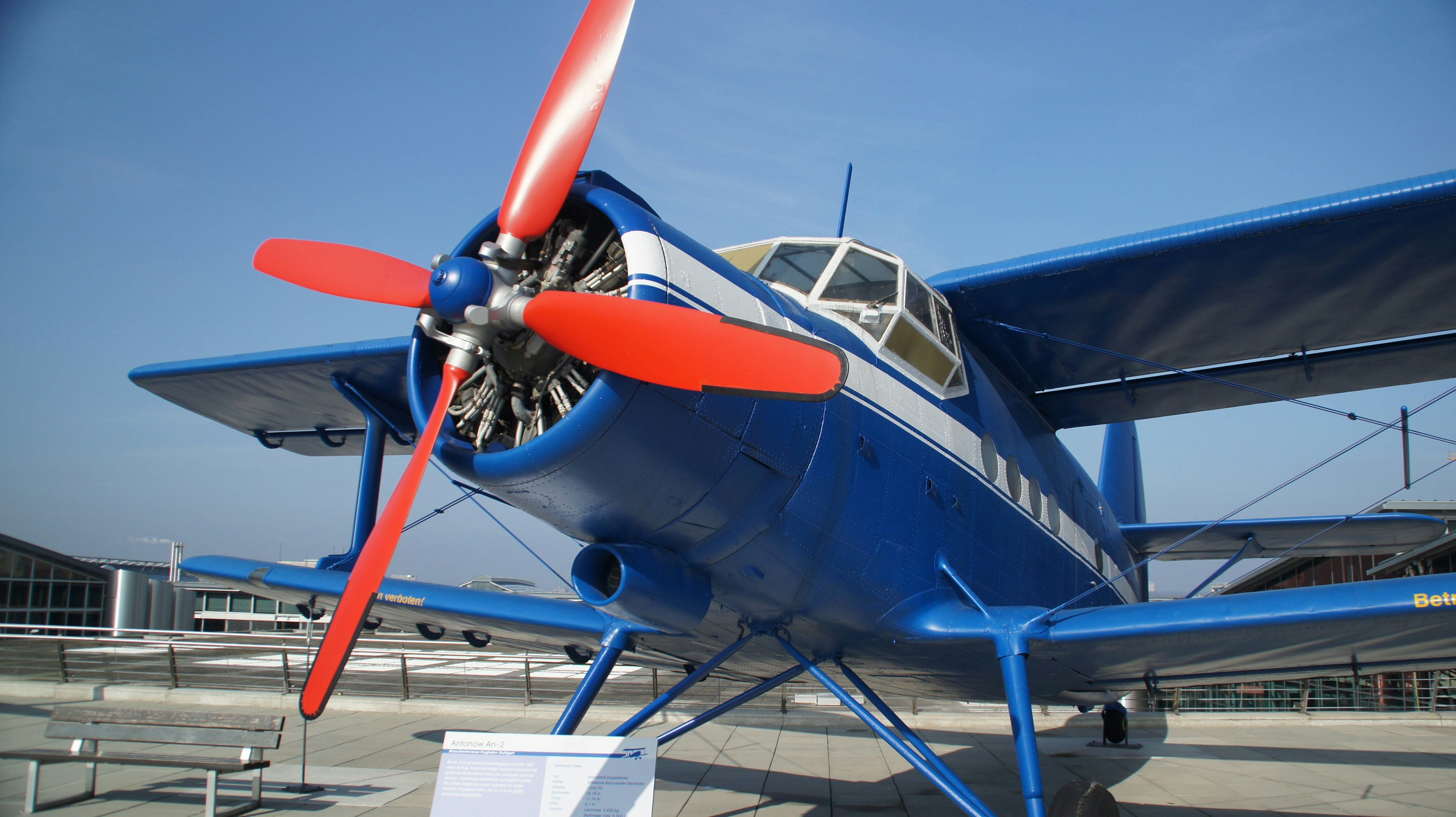 A blue and white propeller airplane on display