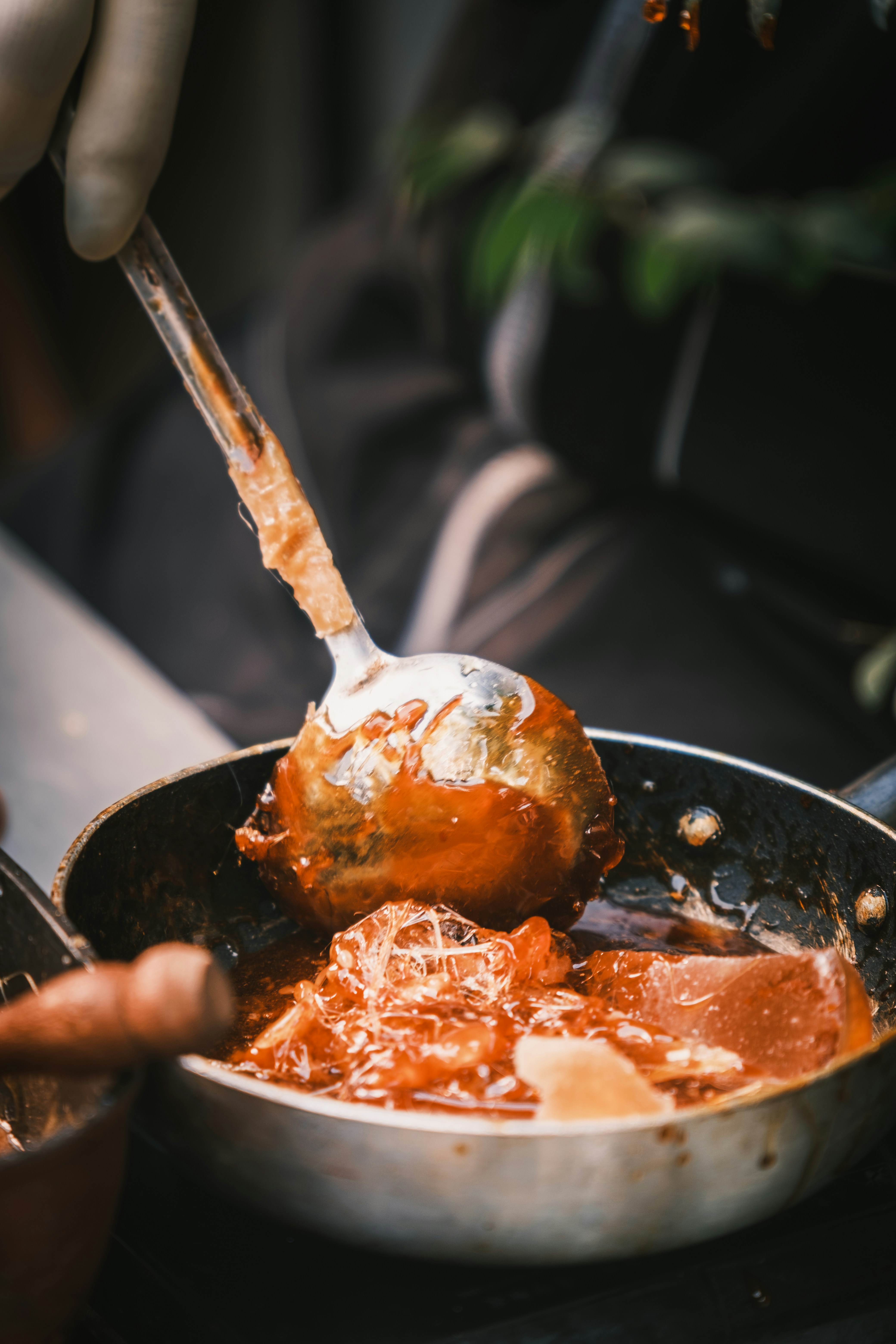 Koch schöpft Sauce aus der Pfanne