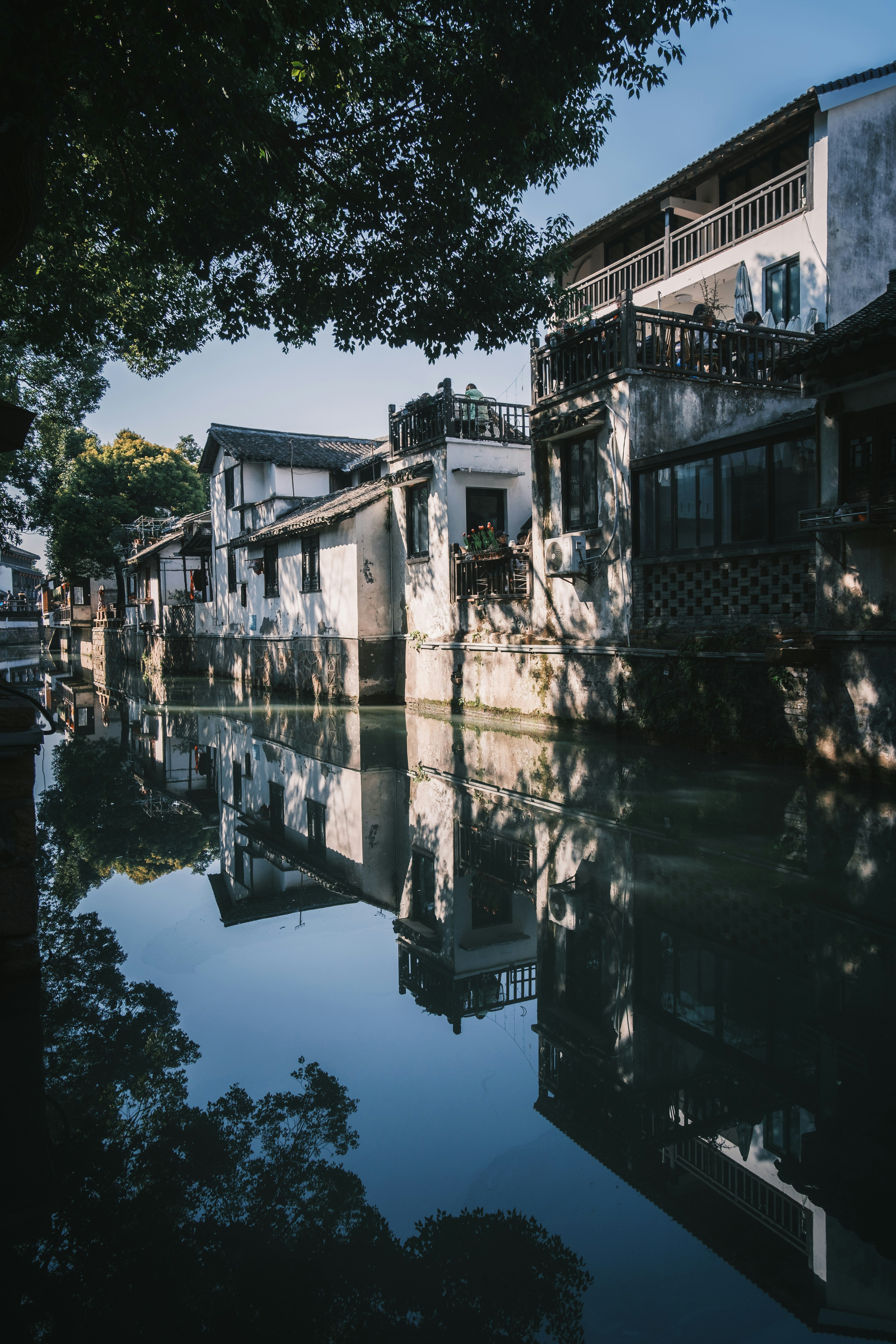 Traditional white buildings reflected in a calm canal.