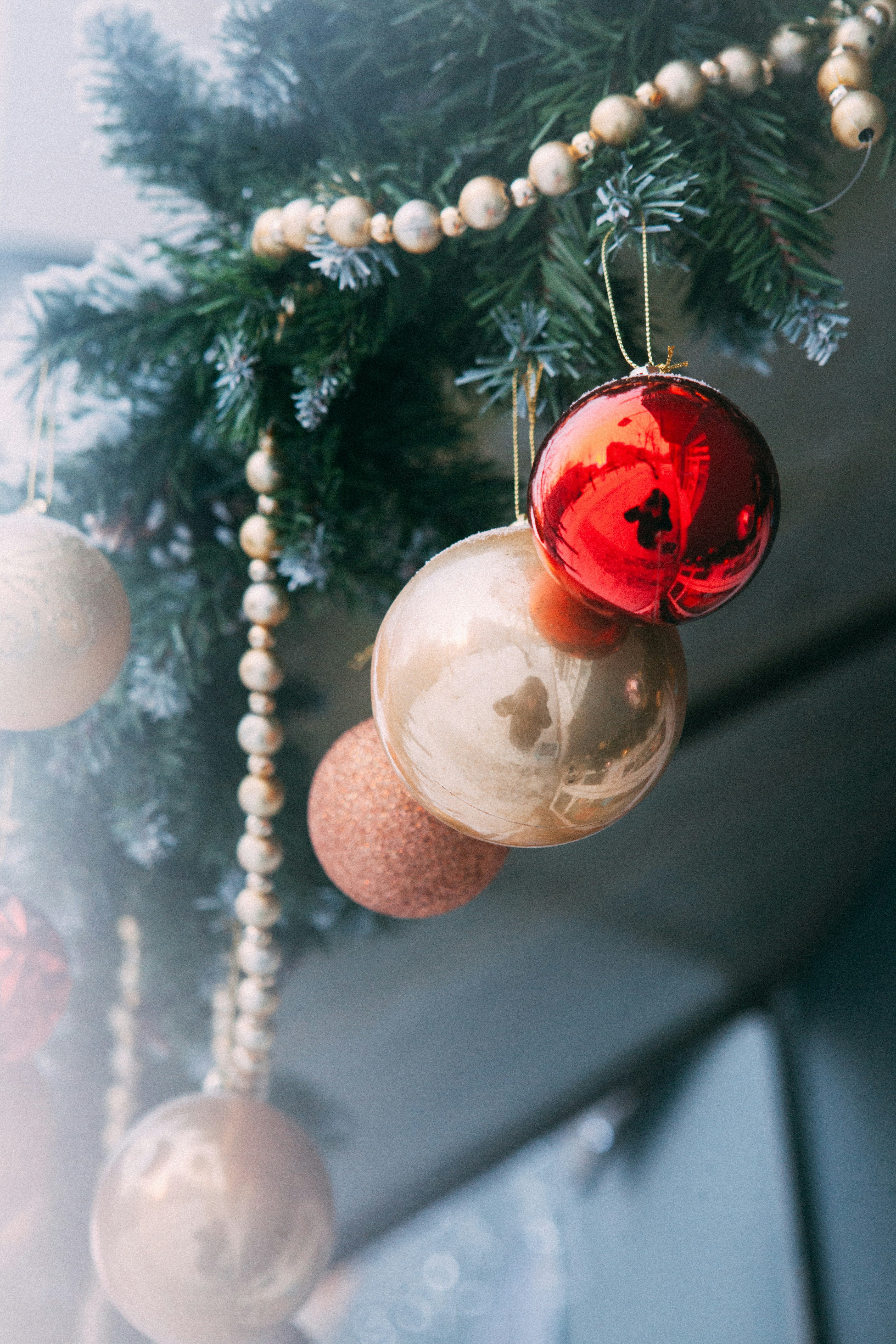 Red and gold christmas ornaments on a pine branch