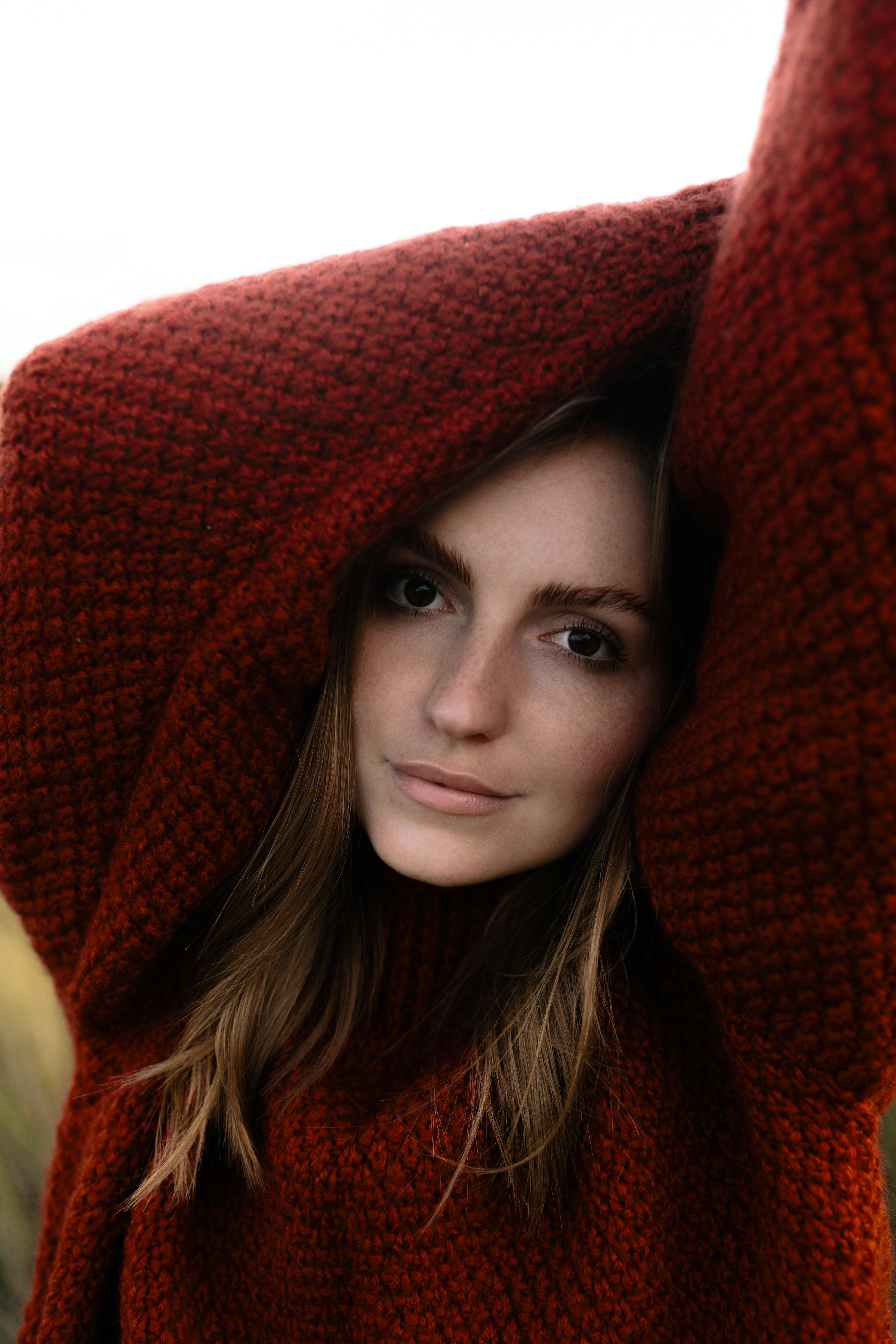 Woman in a cozy, oversized rust-colored sweater