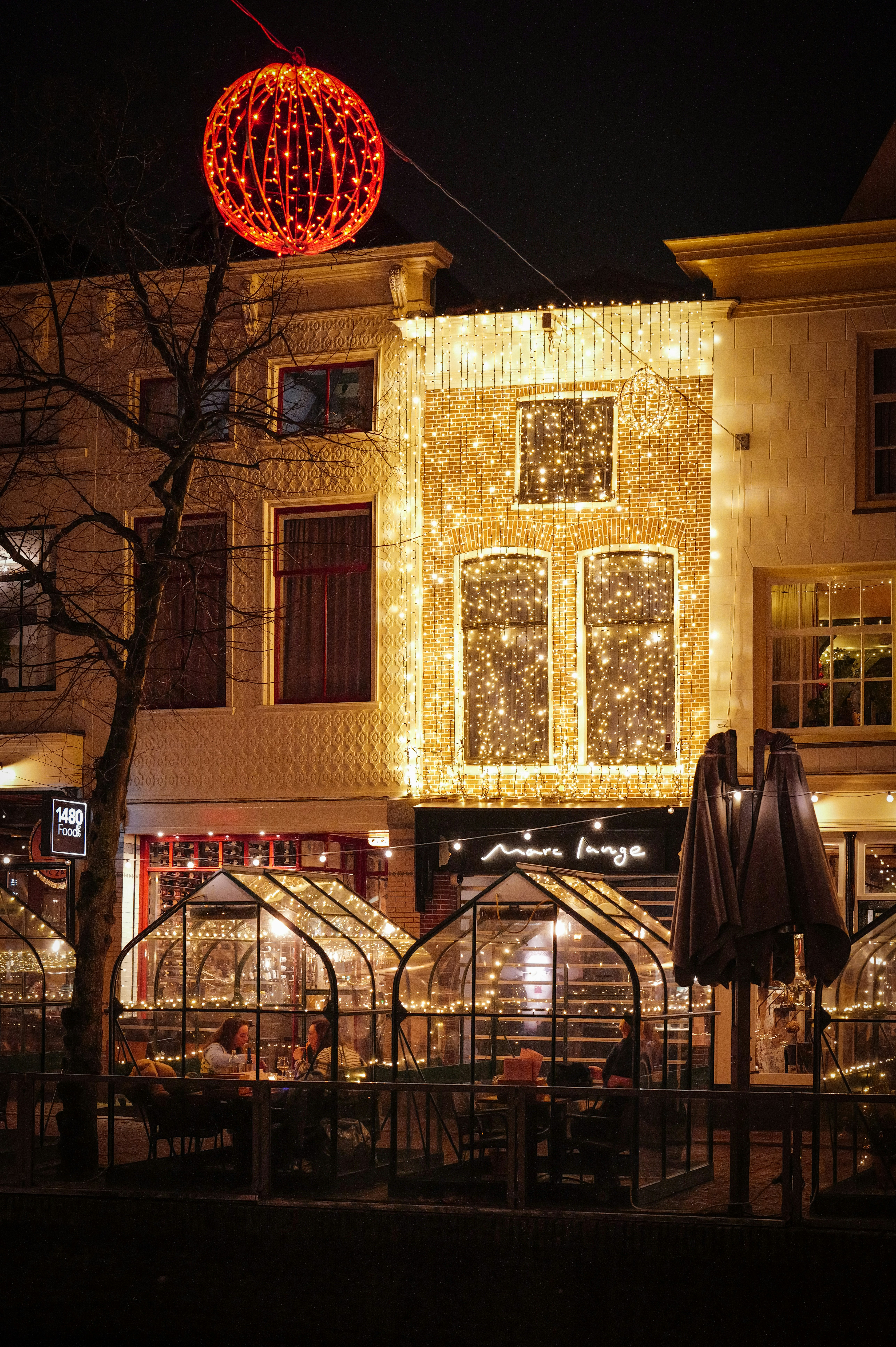 Buildings decorated with festive christmas lights at night