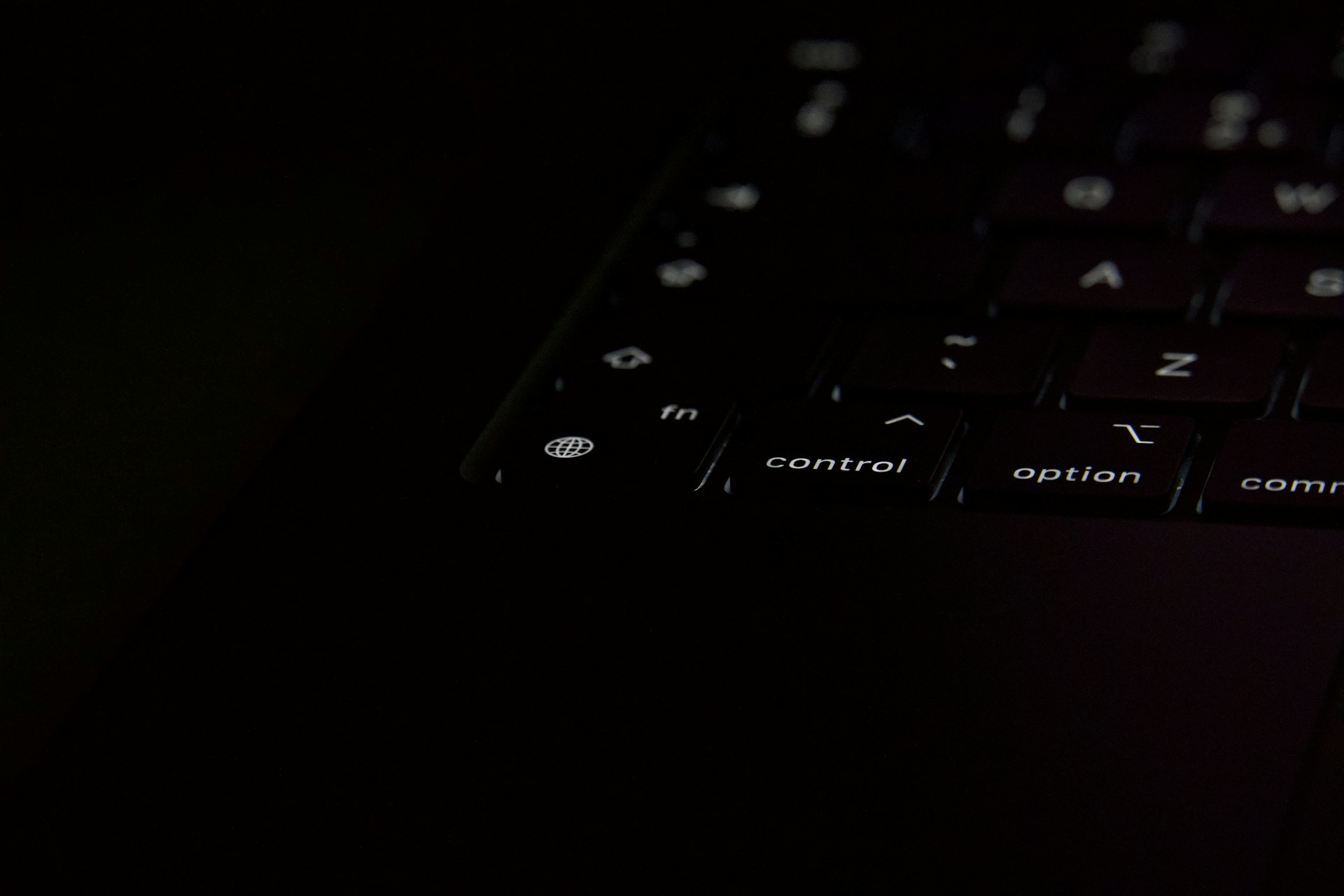 Close-up of a dark laptop keyboard with illuminated keys.