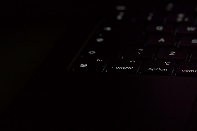 Close-up of a dark laptop keyboard with illuminated keys