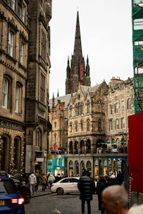 Historic buildings line a street with people walking.
