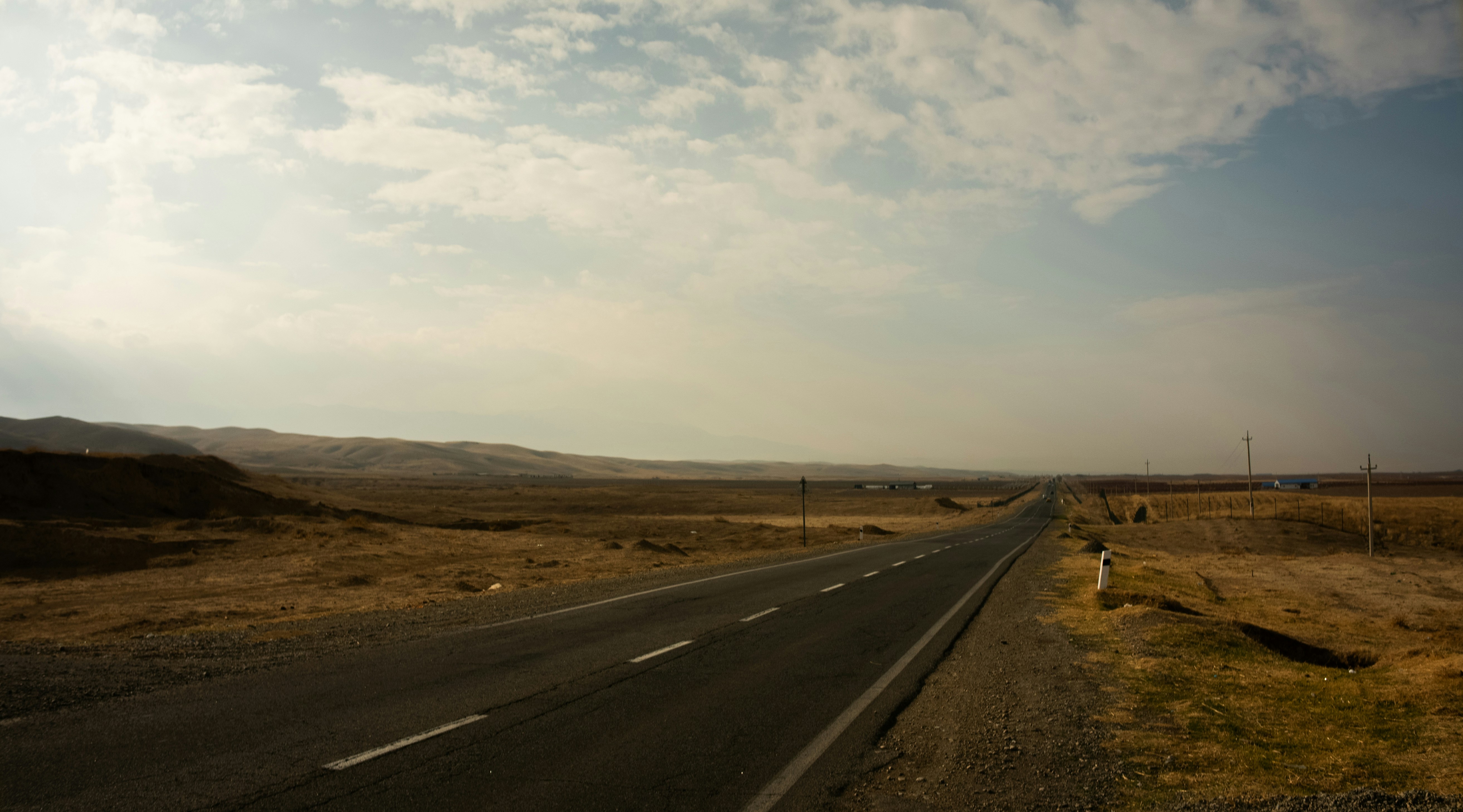 An empty asphalt road stretches into the distance.