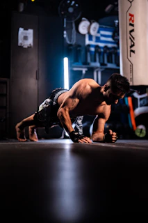 Man doing a plank exercise in a gym.