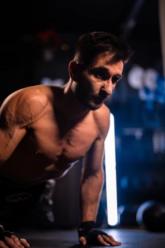 Man doing push-ups in a dimly lit gym
