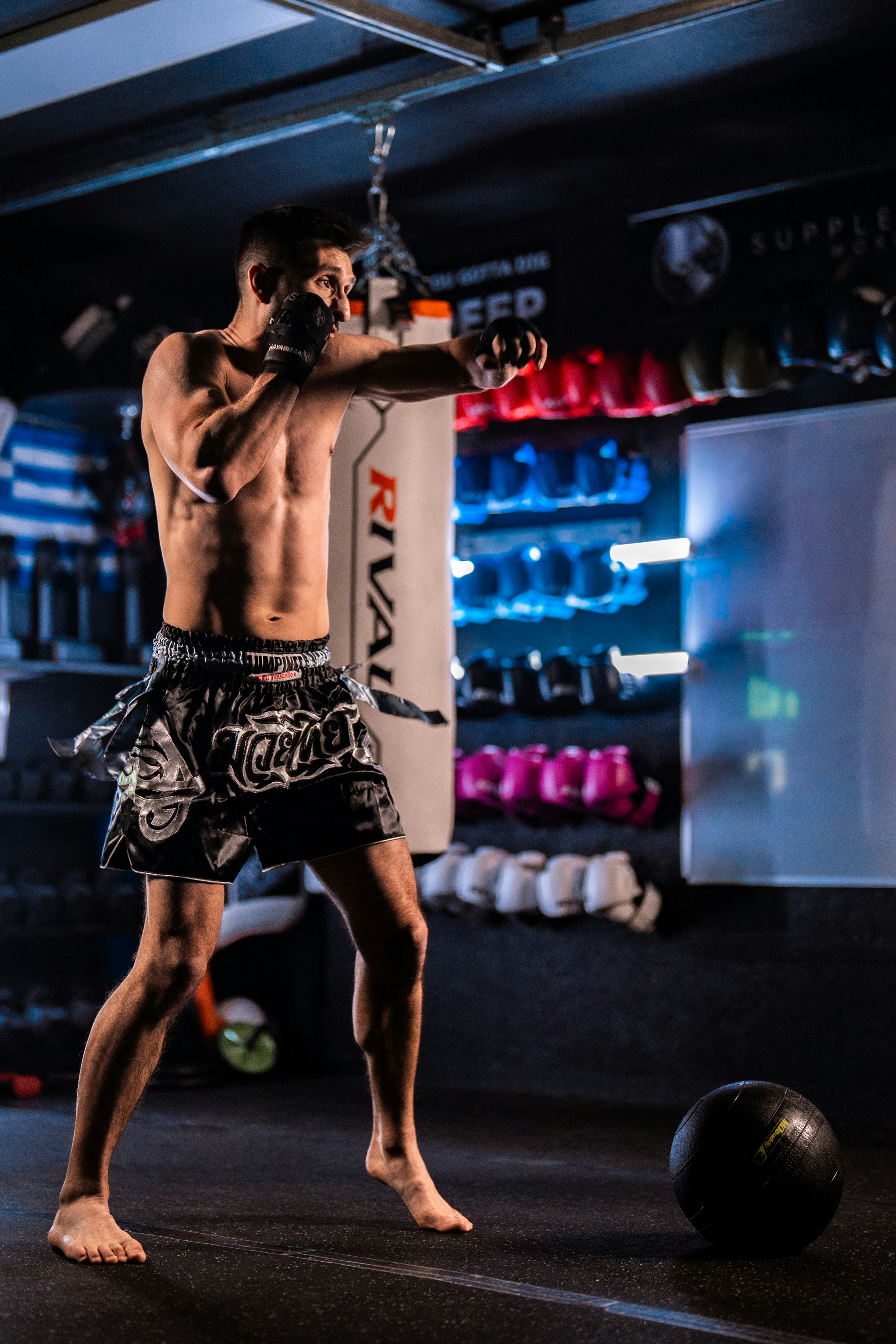 Man training with a punching bag in a gym.