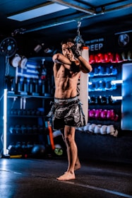 Man practicing muay thai boxing in a gym.