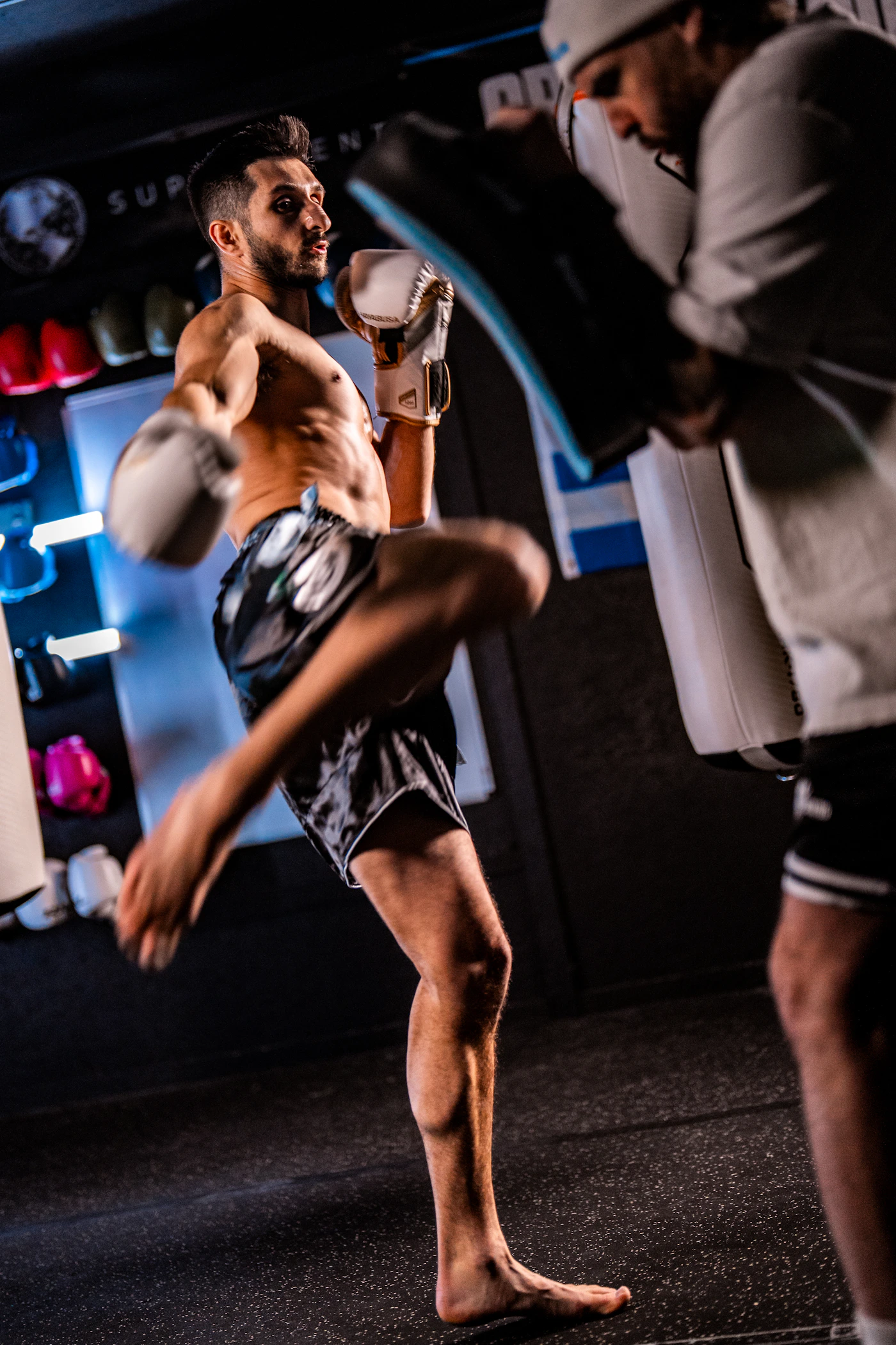 Treino de Boxe com atleta e treinador trabalhando manoplas