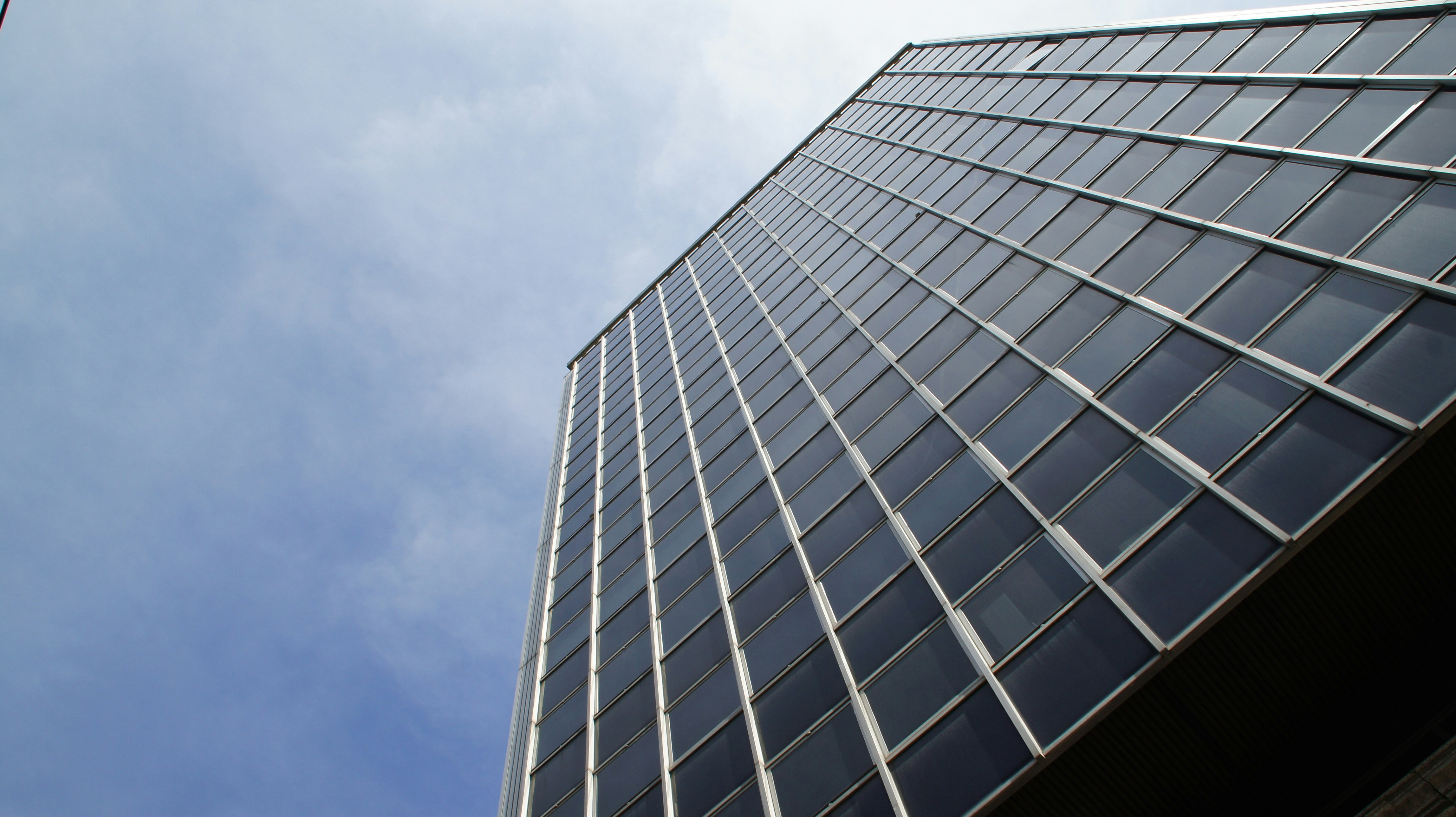 Modern glass building against a blue sky