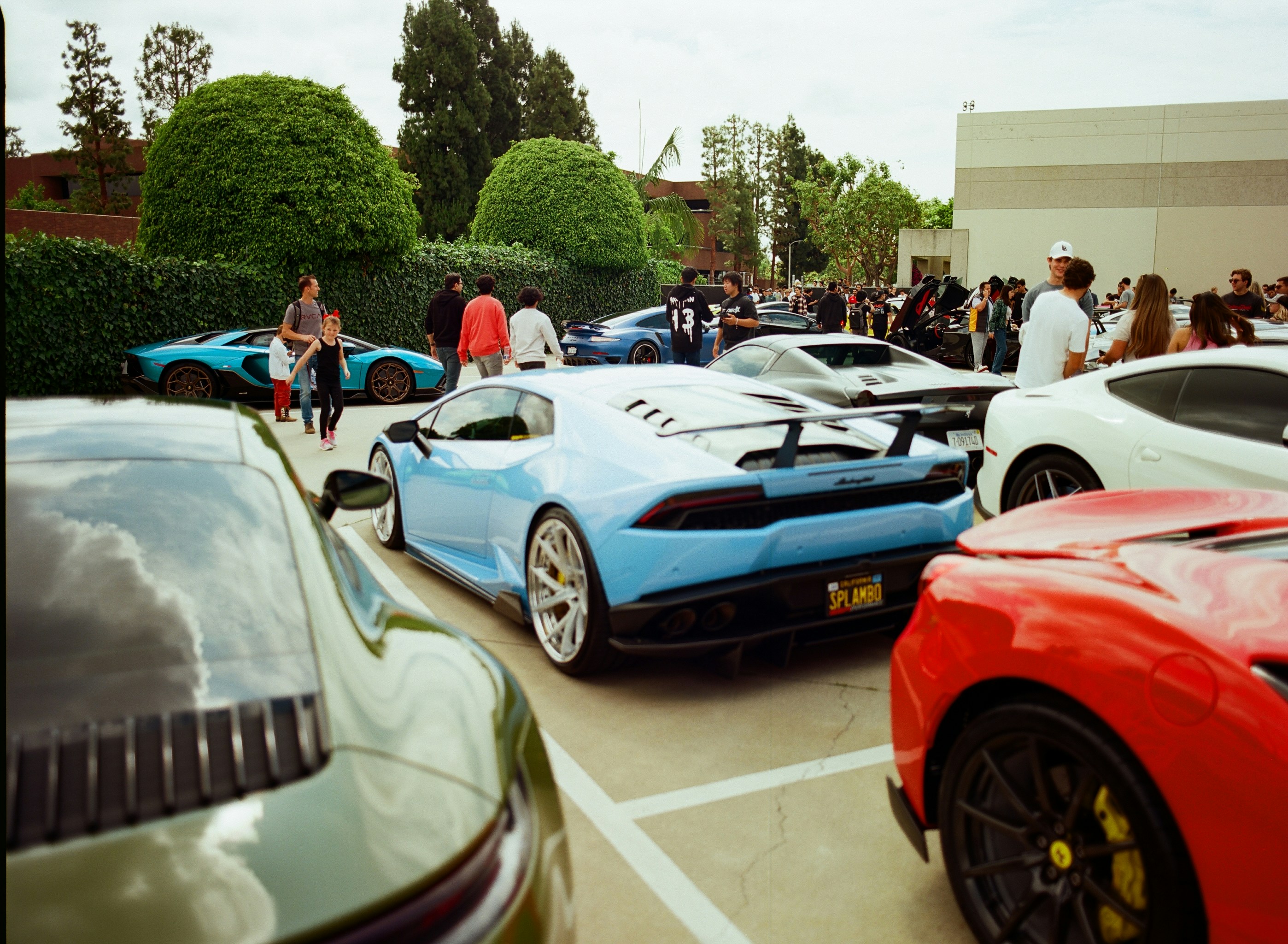 Several luxury cars parked at an outdoor event.
