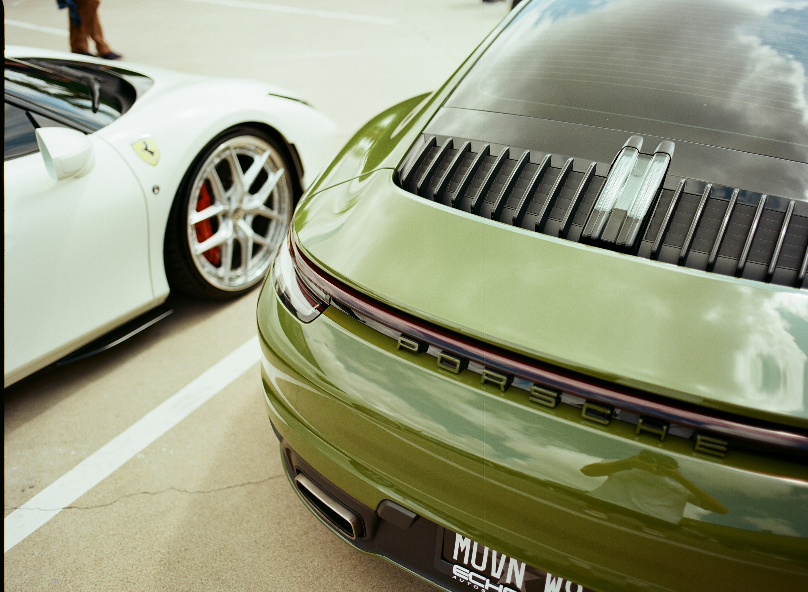 Two luxury sports cars, green and white.