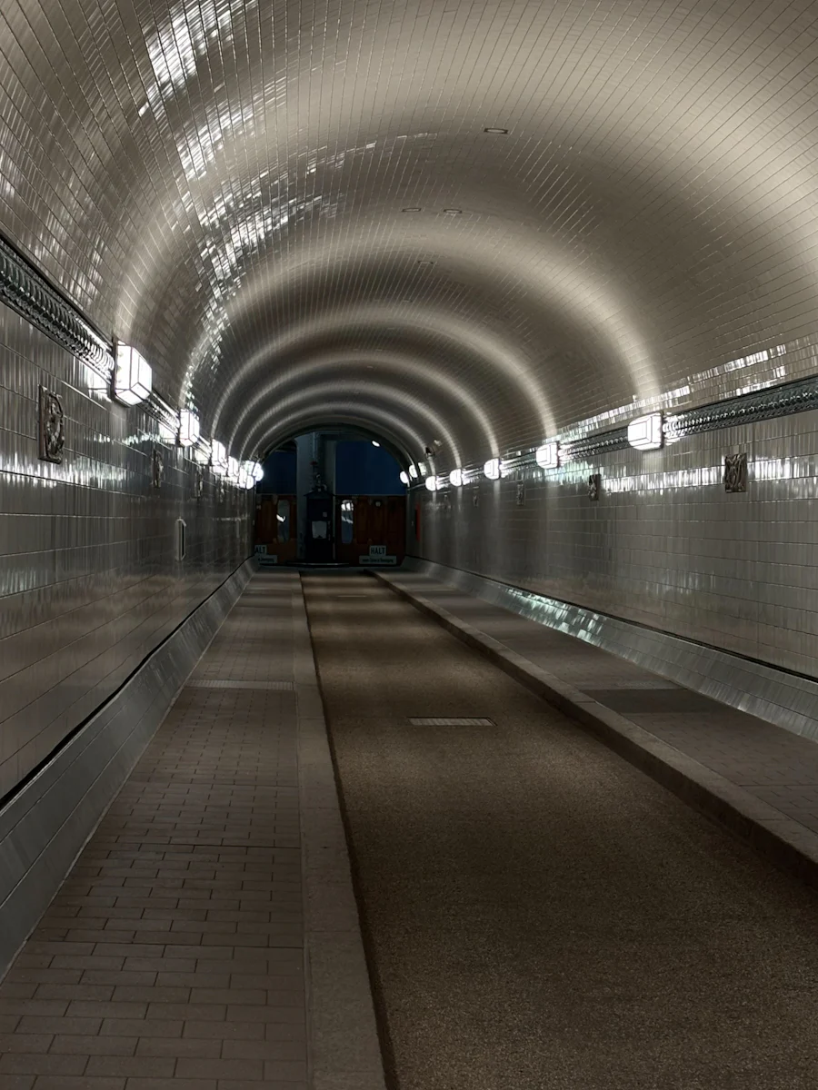 Gekachelte Röhre des Alten Elbtunnels mit Lampen an den Wänden