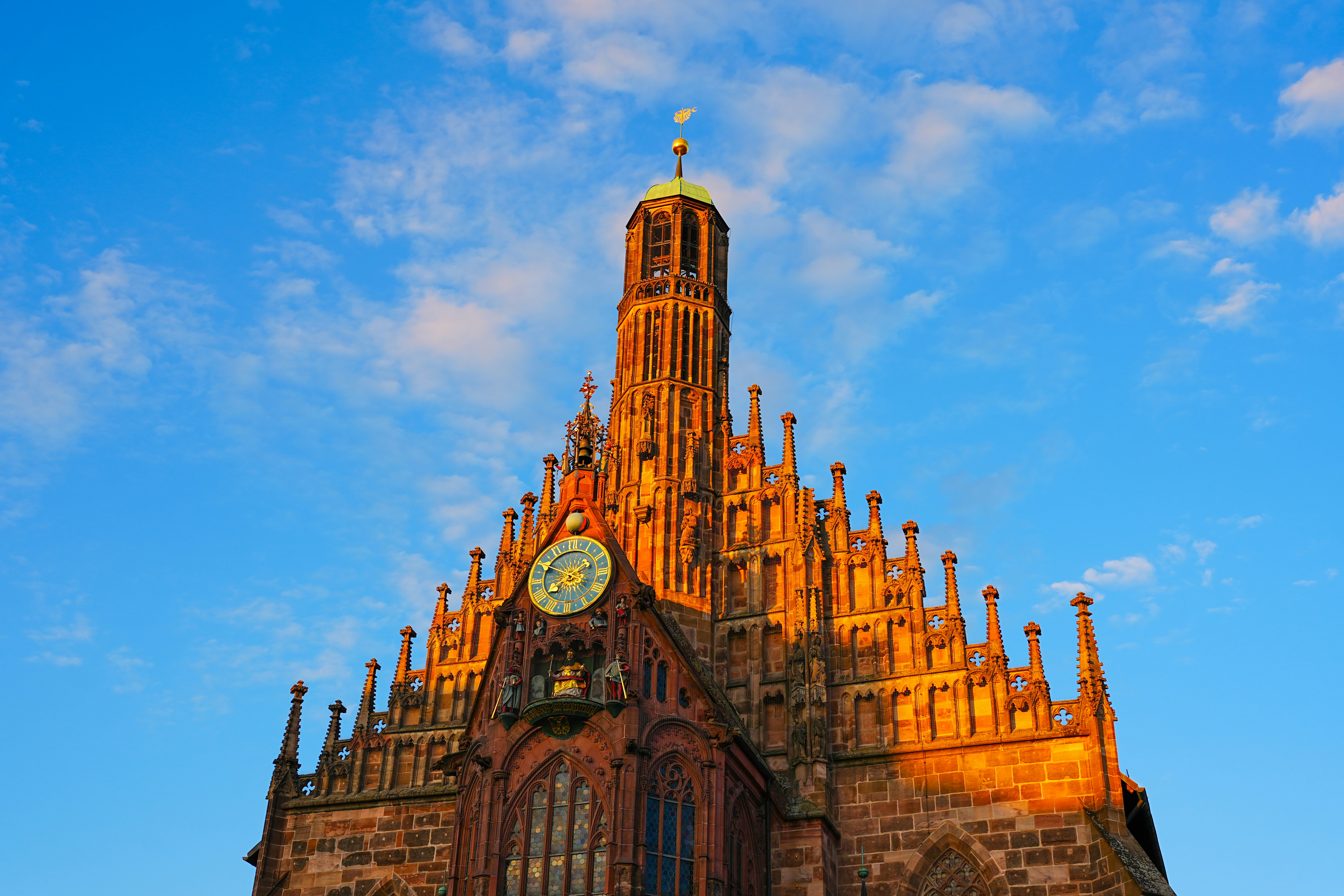 Gothic church tower illuminated by golden sunset light.