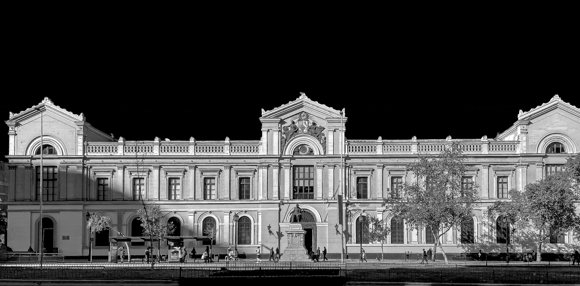 Grand building with trees and dark sky