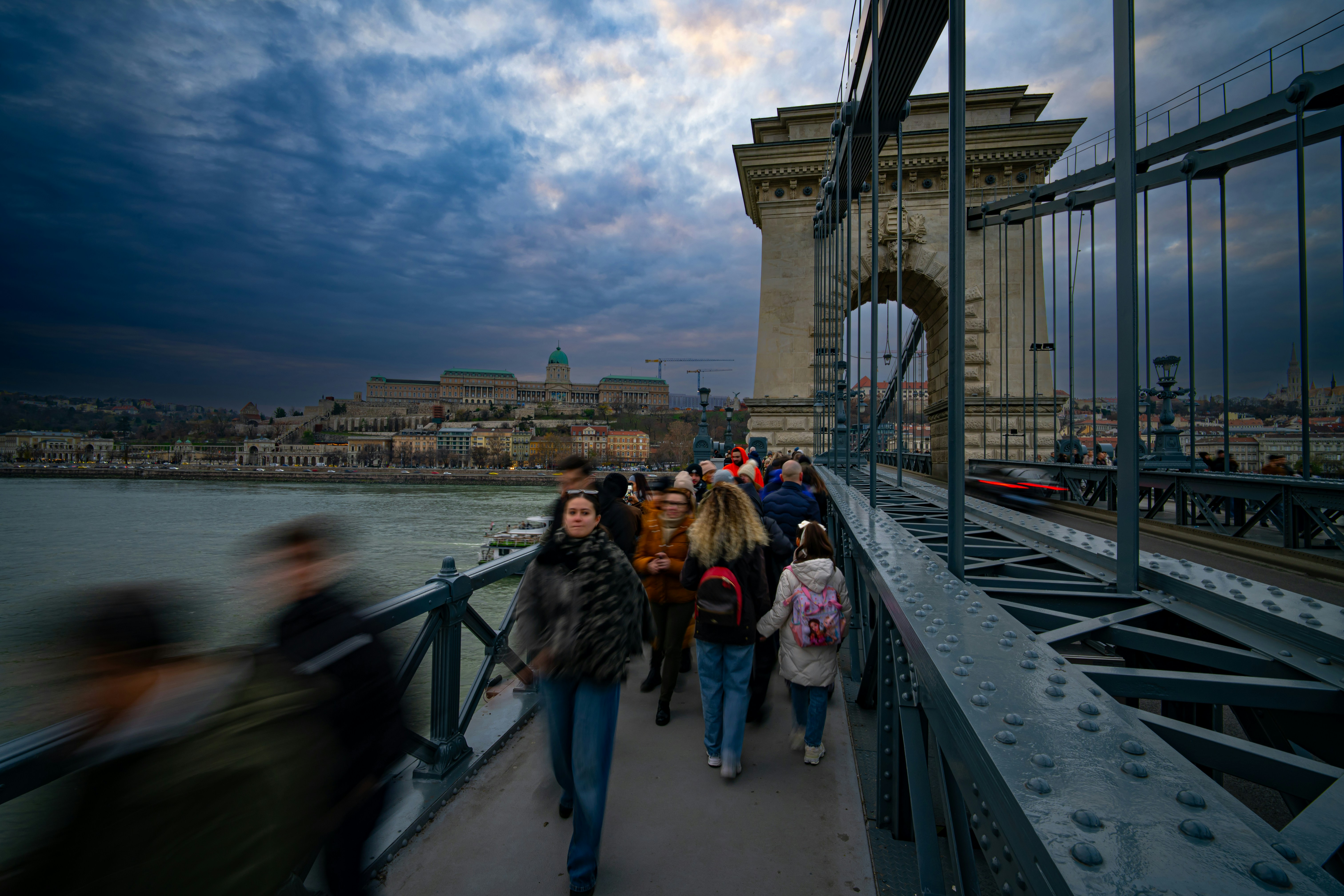 People walking on a bridge with city in background