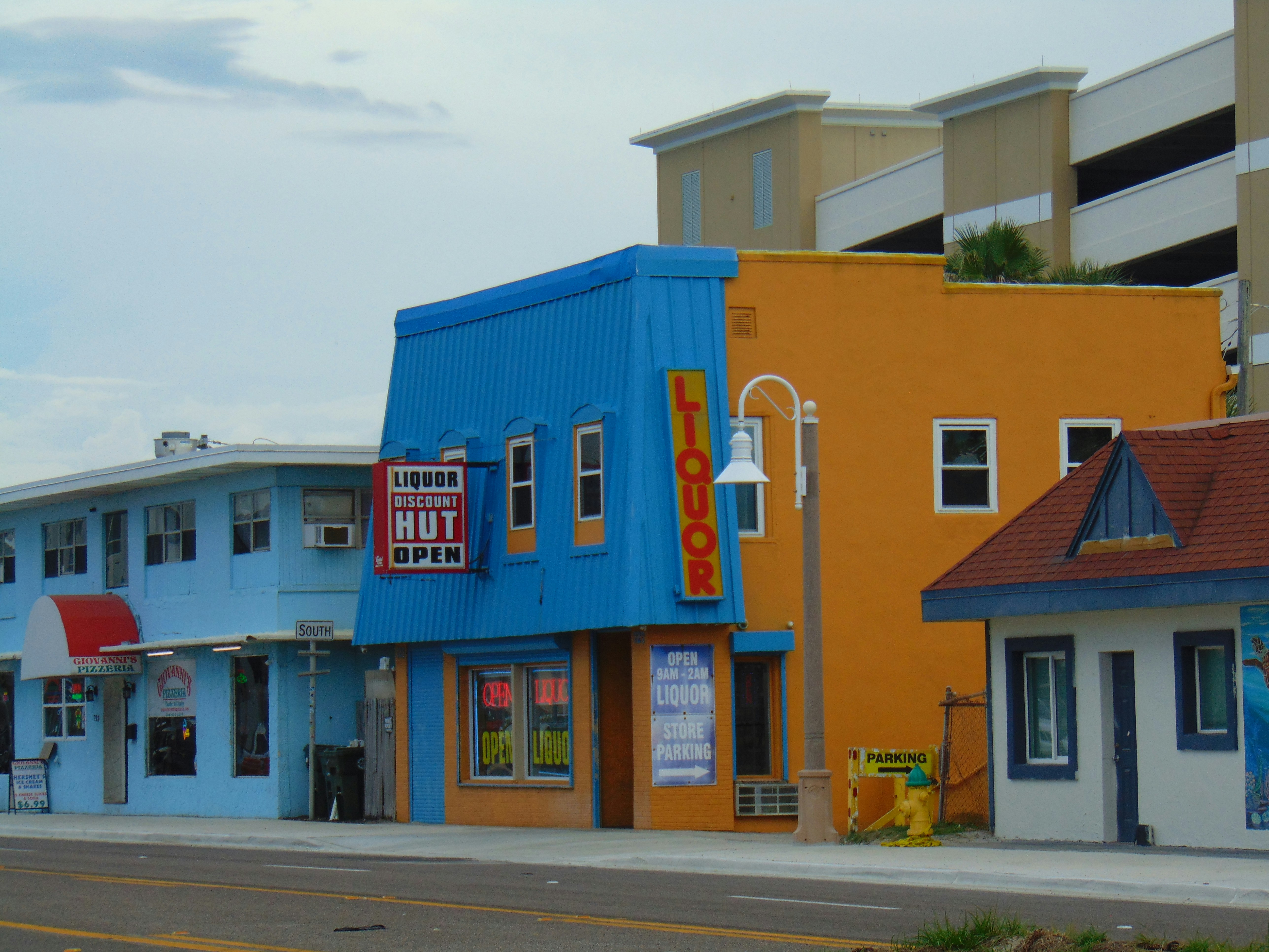 Colorful buildings with liquor store sign on a street.