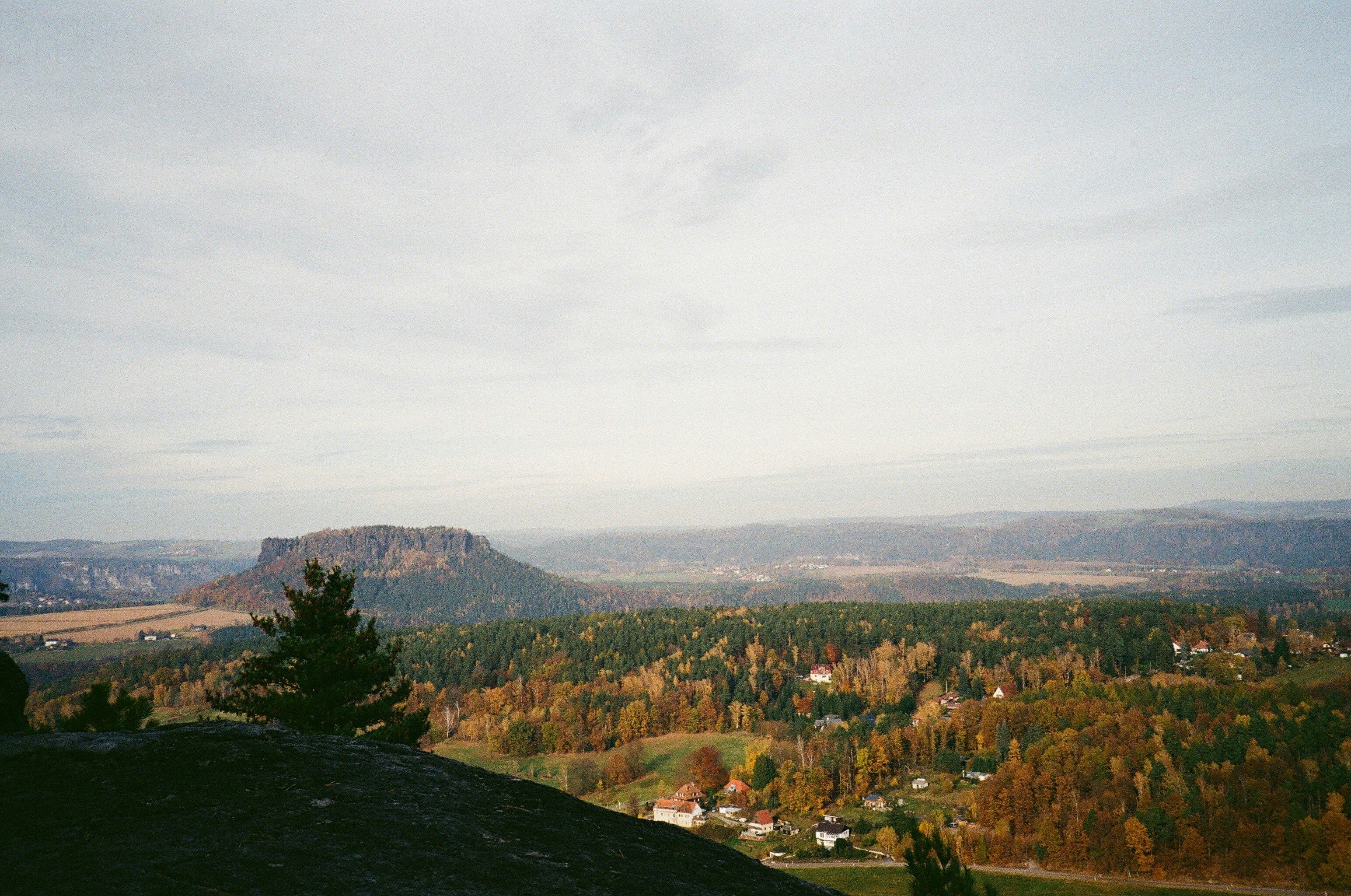 Herbstlandschaft mit sanften Hügeln und fernen Bergen.