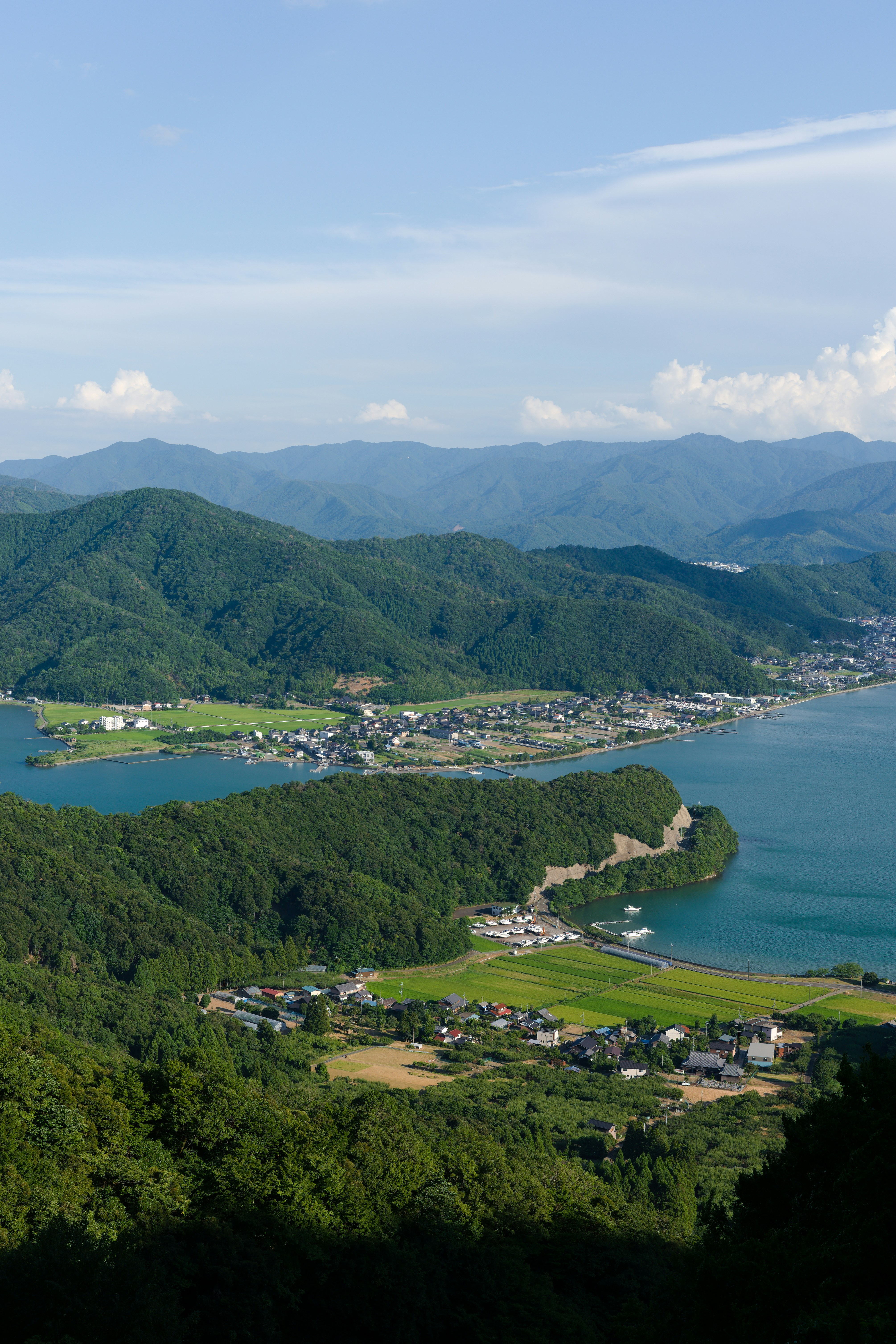 Lush green mountains surround a tranquil blue lake.