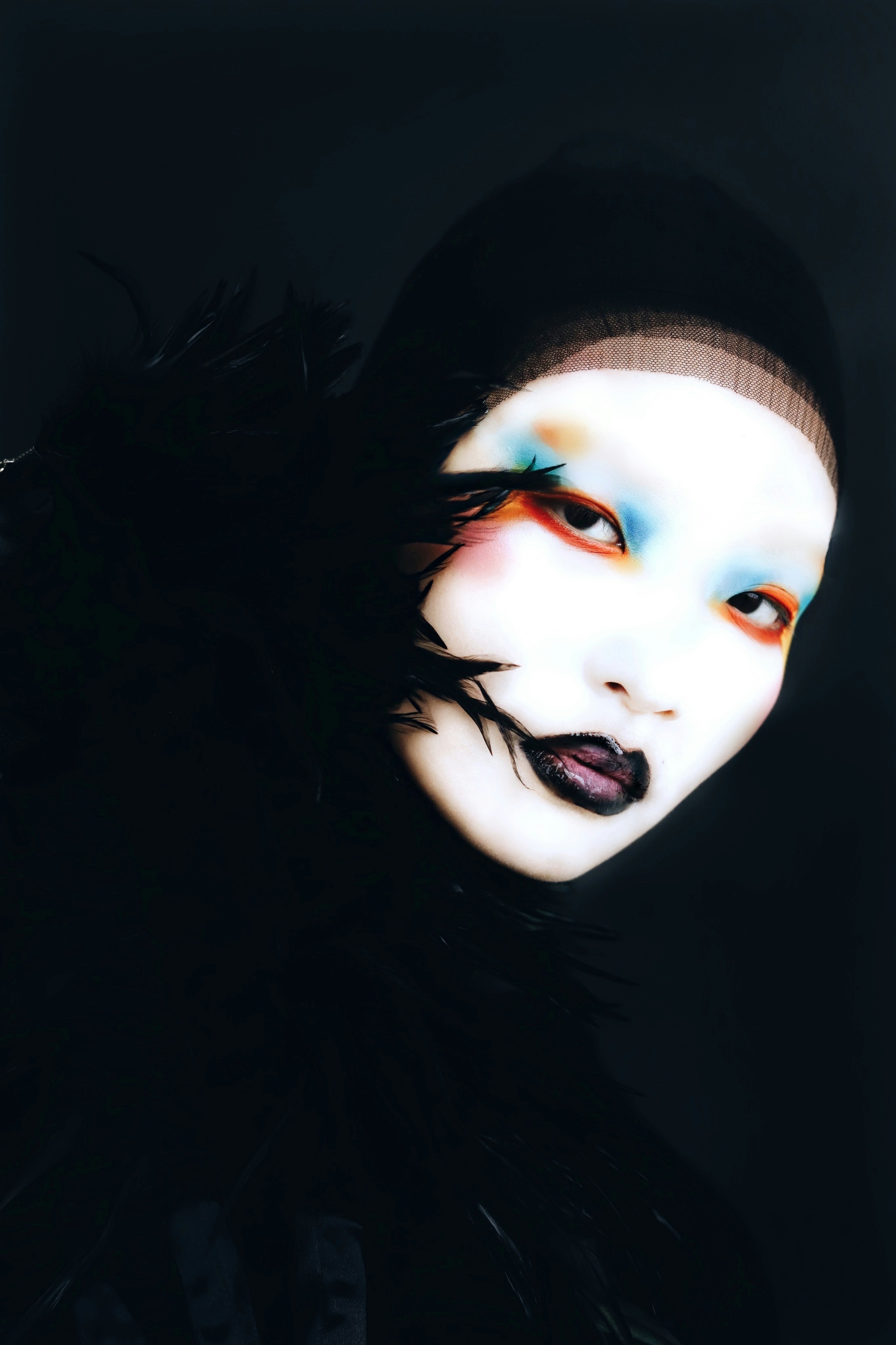 Woman with dramatic makeup and black feathers