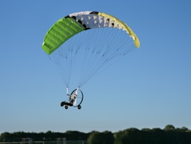 Paramotor flying against a clear blue sky