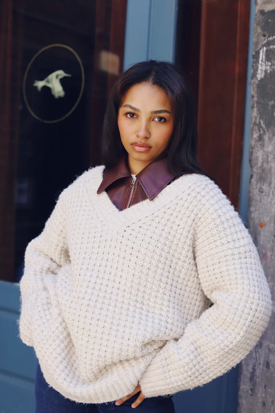 Young woman in a cream sweater with a brown collar