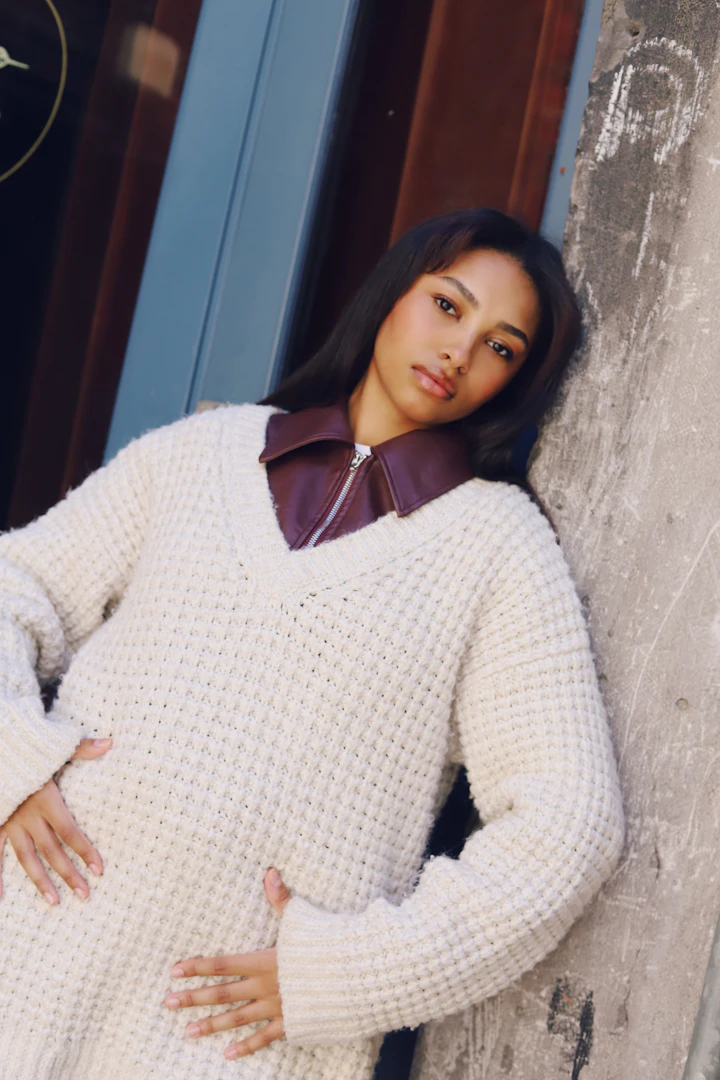 Editorial portrait of a woman in a heavy cream knit sweater