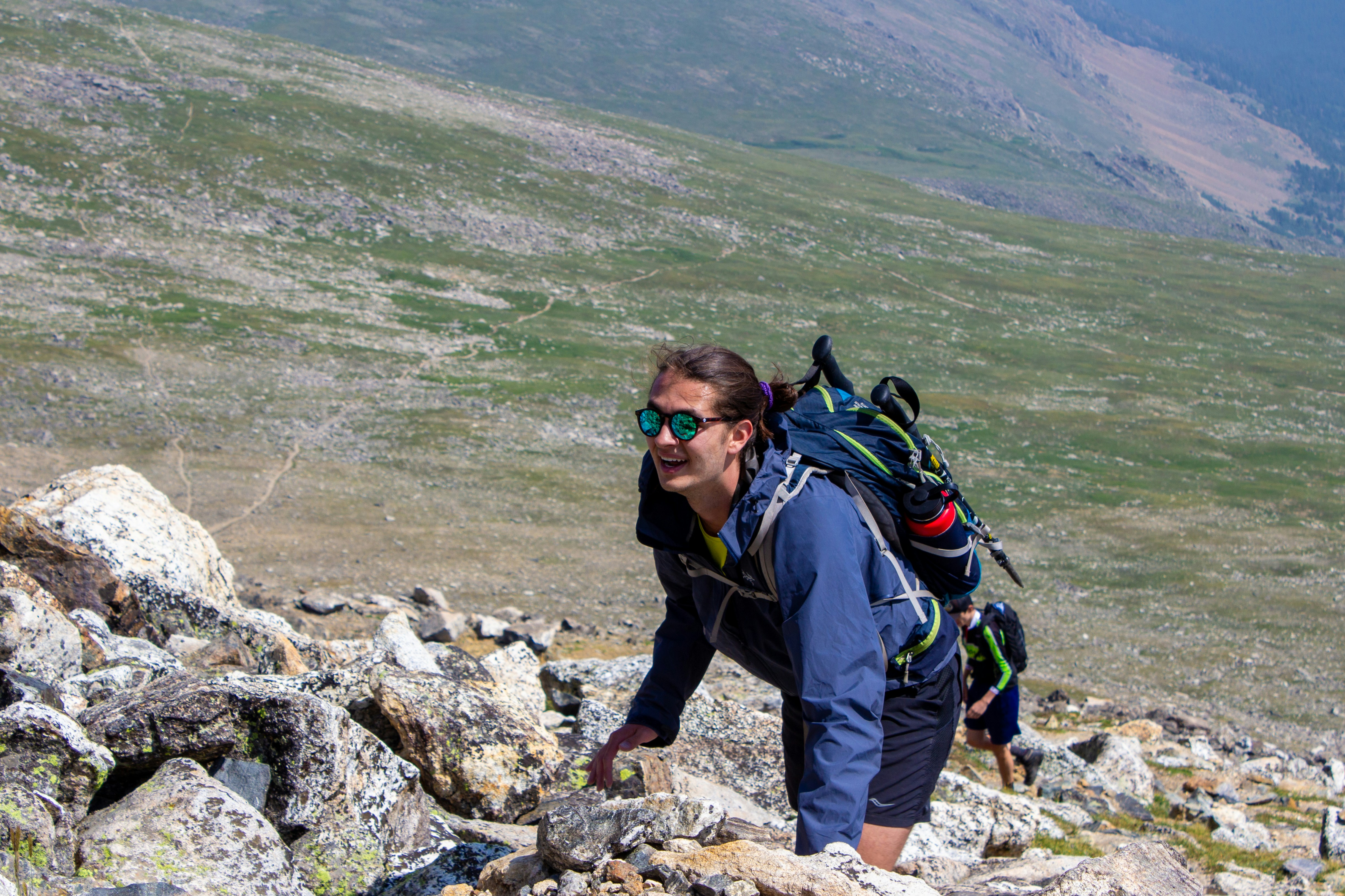 Woman hiking uphill on a rocky mountain trail