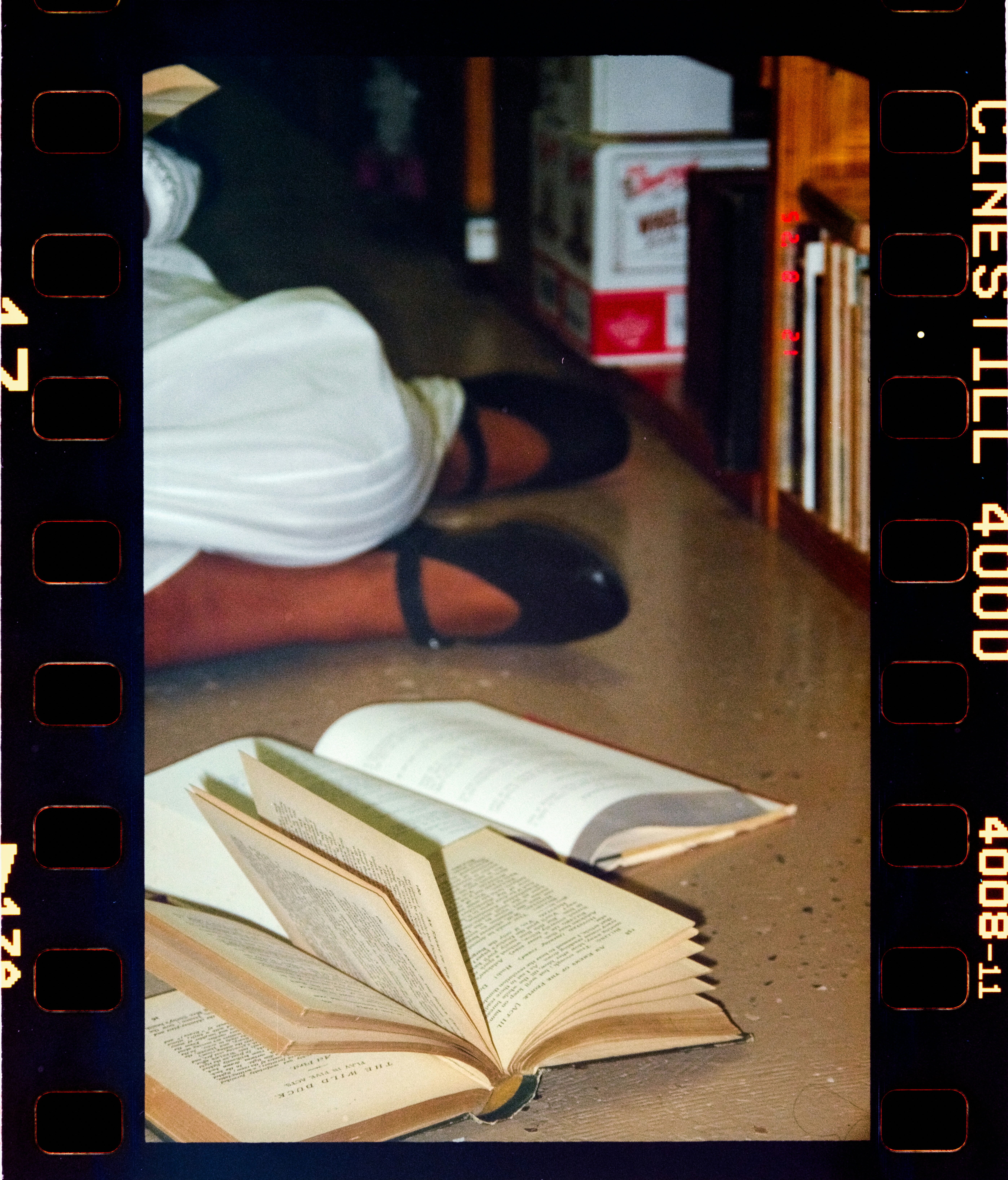 A person sits on the floor with open books.