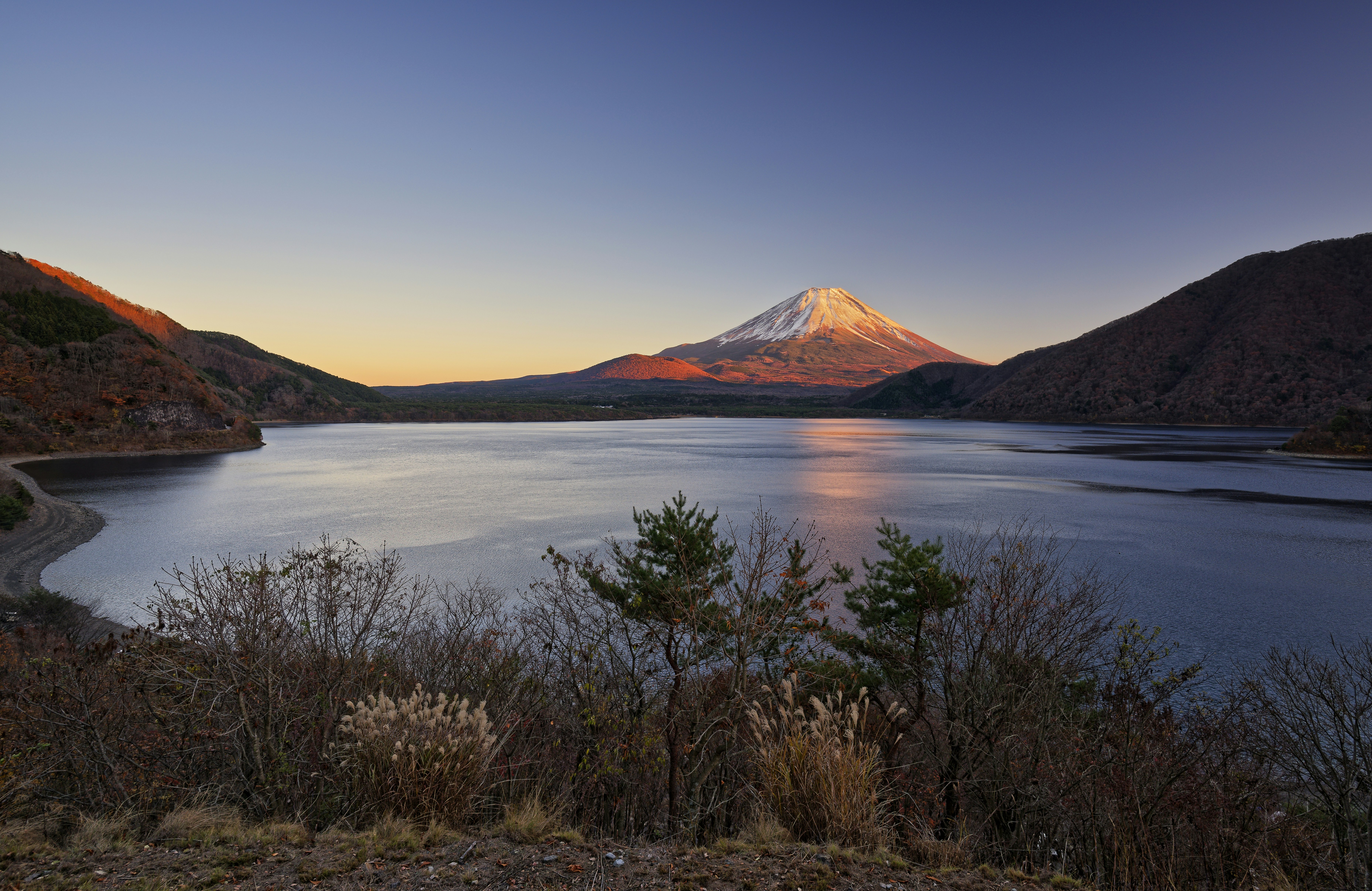 Mount fuji reflected in a calm lake at sunrise.