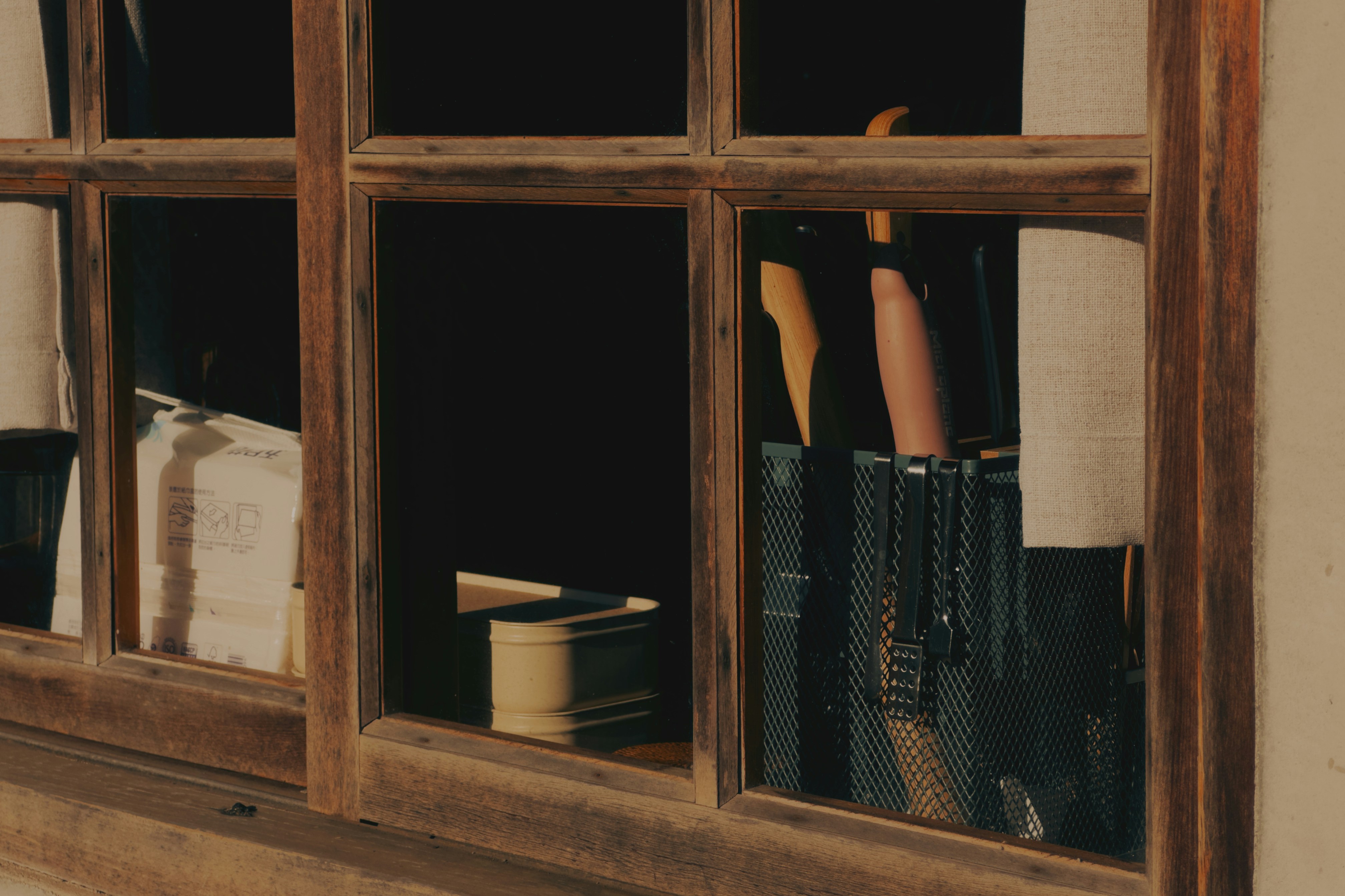 A person reaching for books through a window.