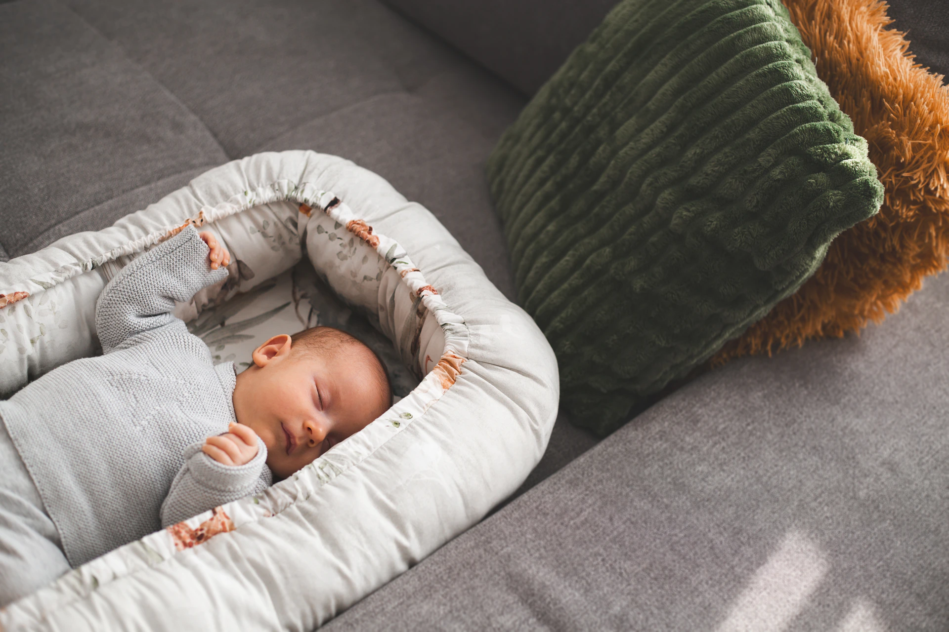 A newborn baby sleeps peacefully in a cozy nest