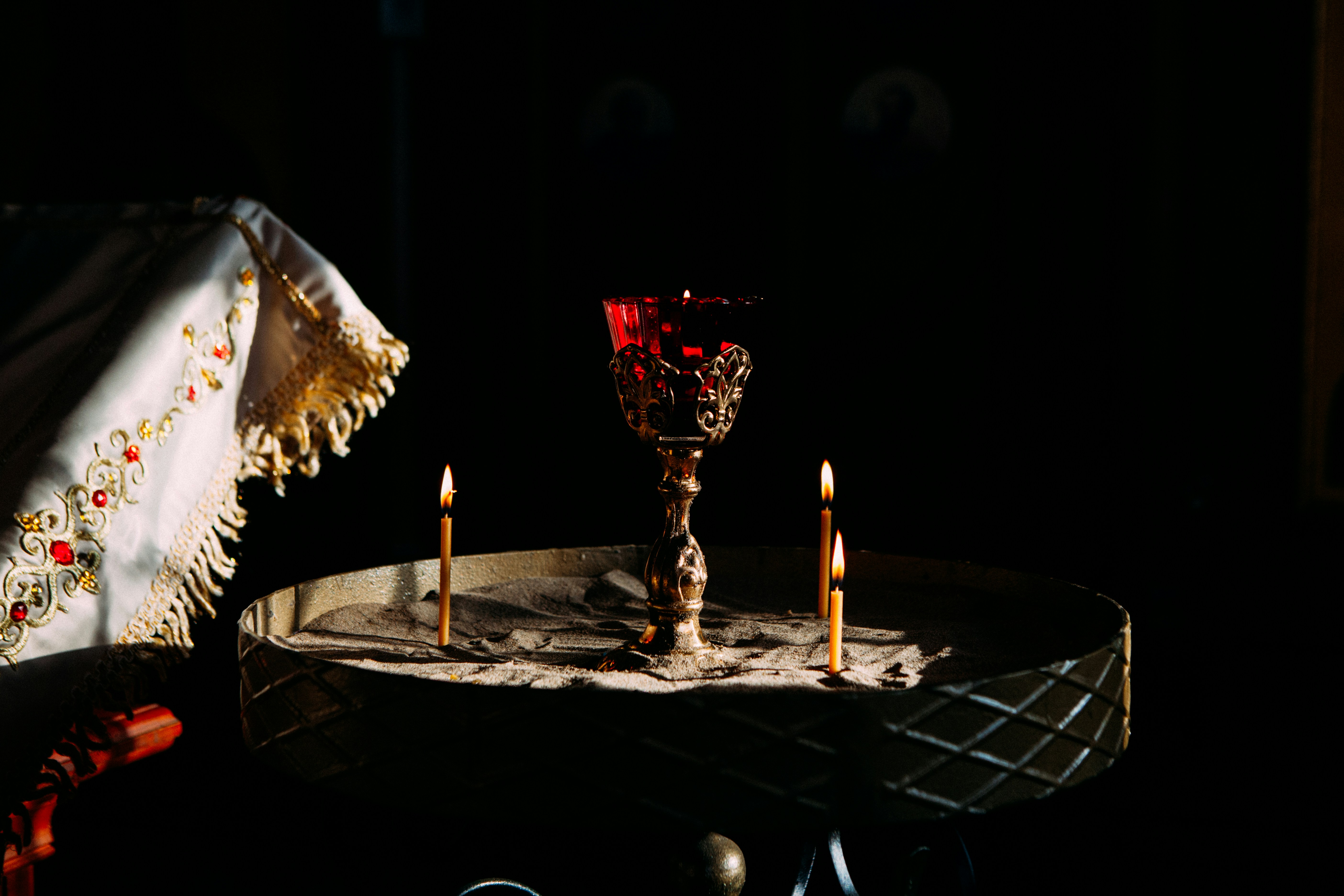 A red chalice with candles on a tray