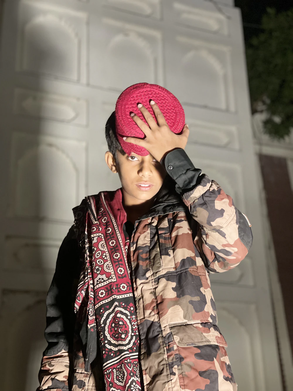 A woman wrapped in a red printed textile