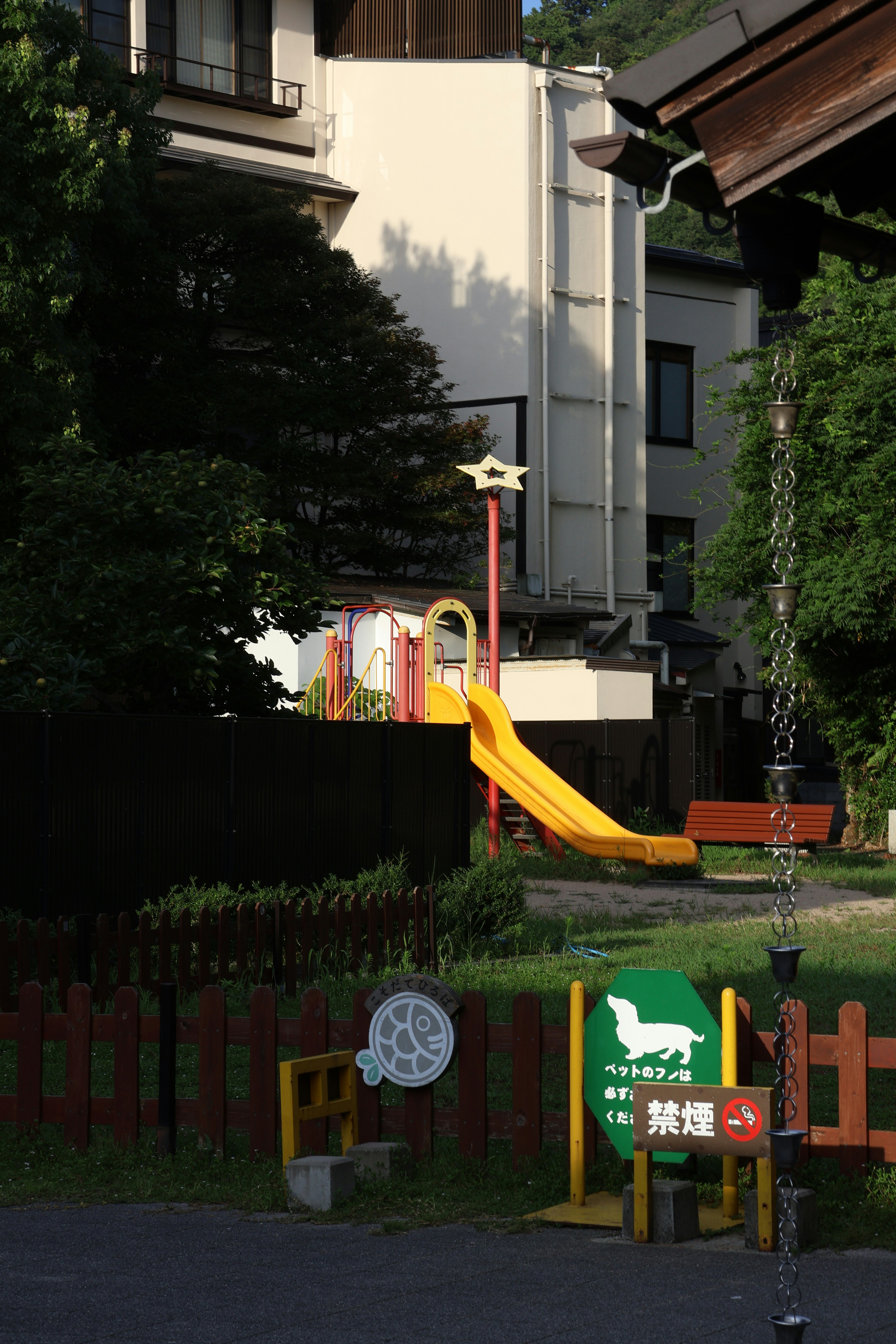 Playhouse with slide and climbing wall in a residential backyard