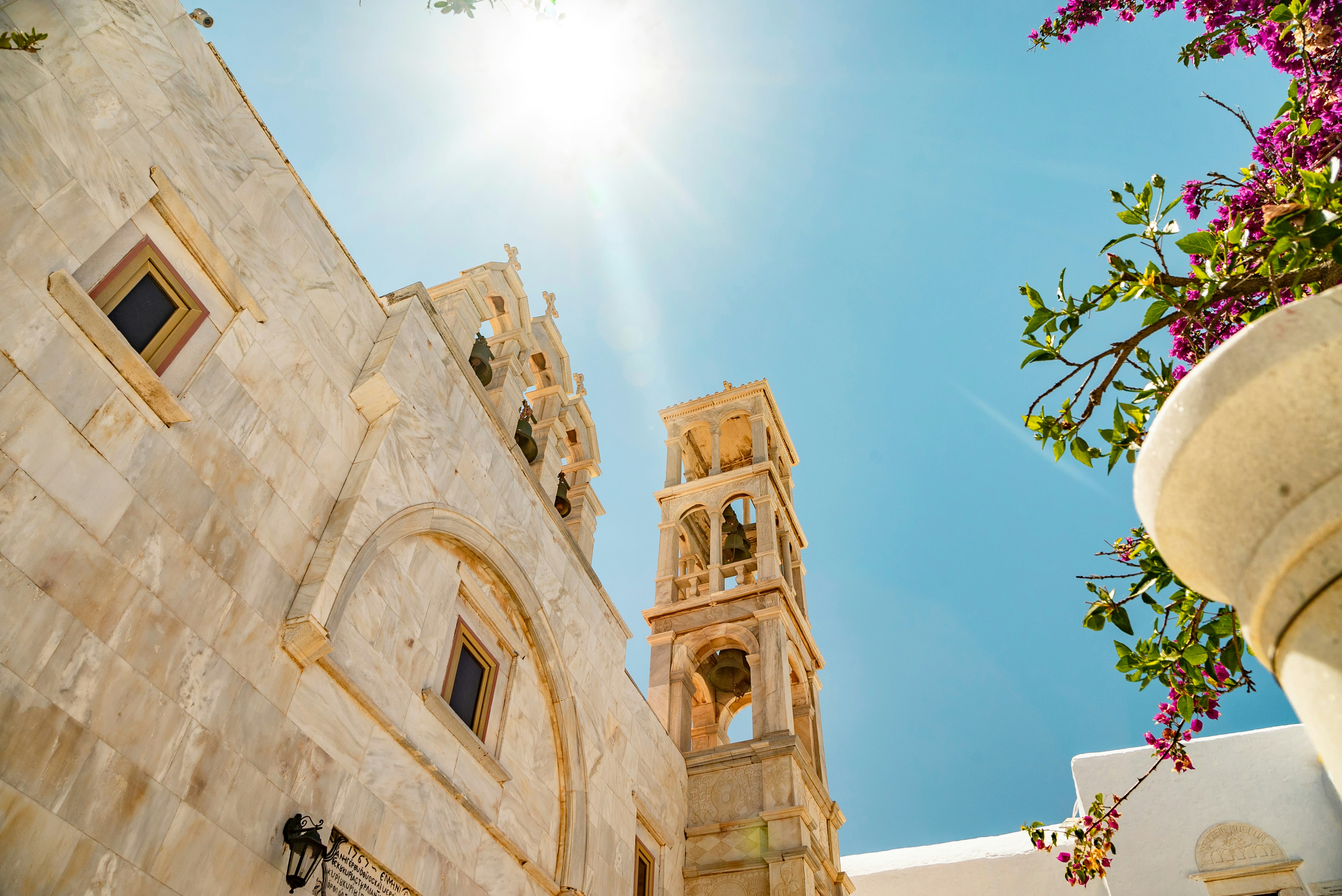 White stone building with bell tower under bright sun