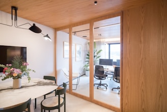 Modern office space with dining area and glass partition.