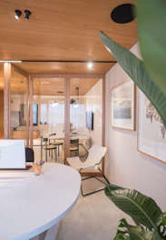 Modern office interior with glass walls and plants.