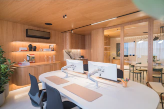 Modern office with wooden accents and dual monitors.