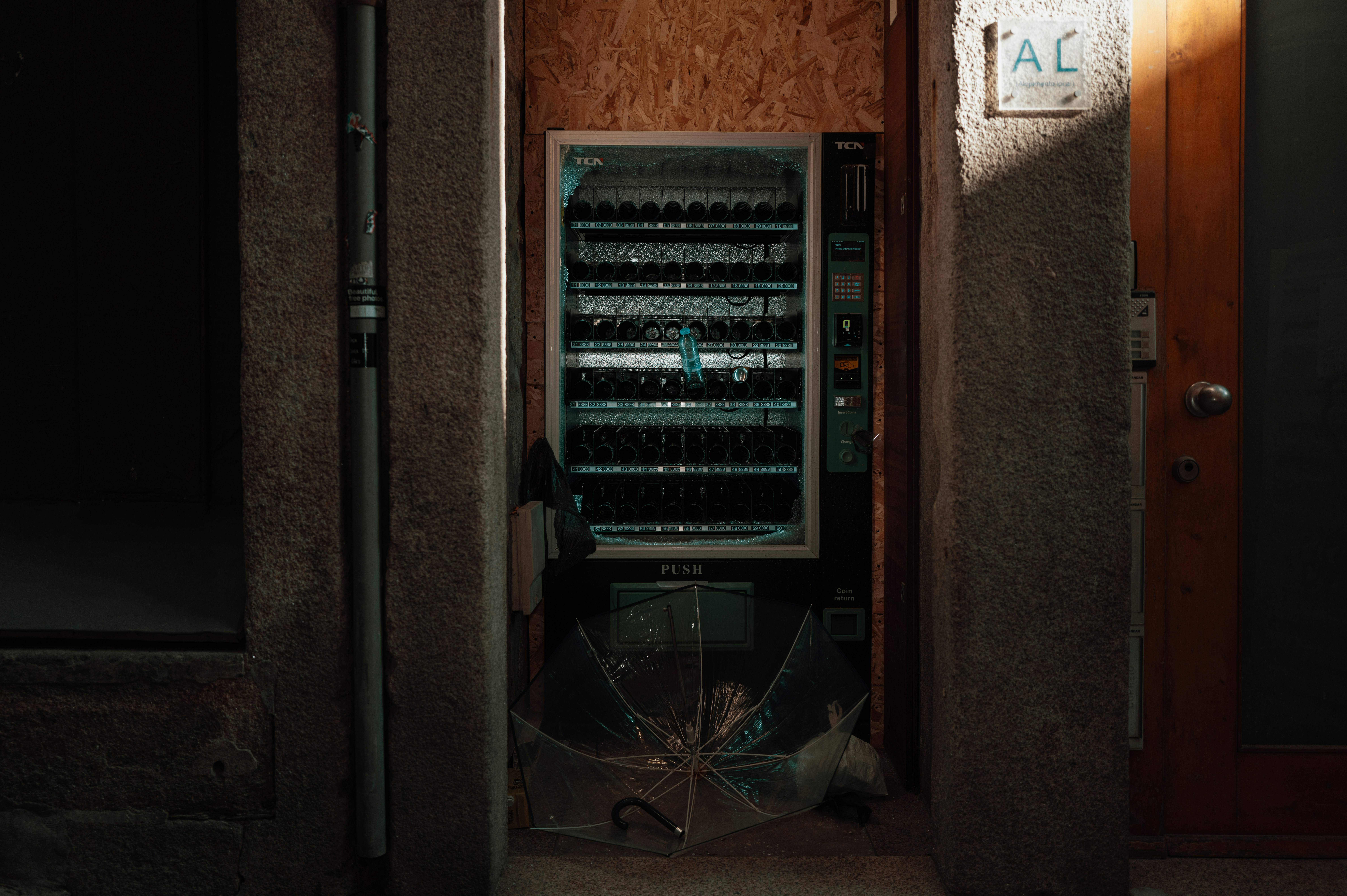 Un distributeur automatique dans une ruelle faiblement éclairée.