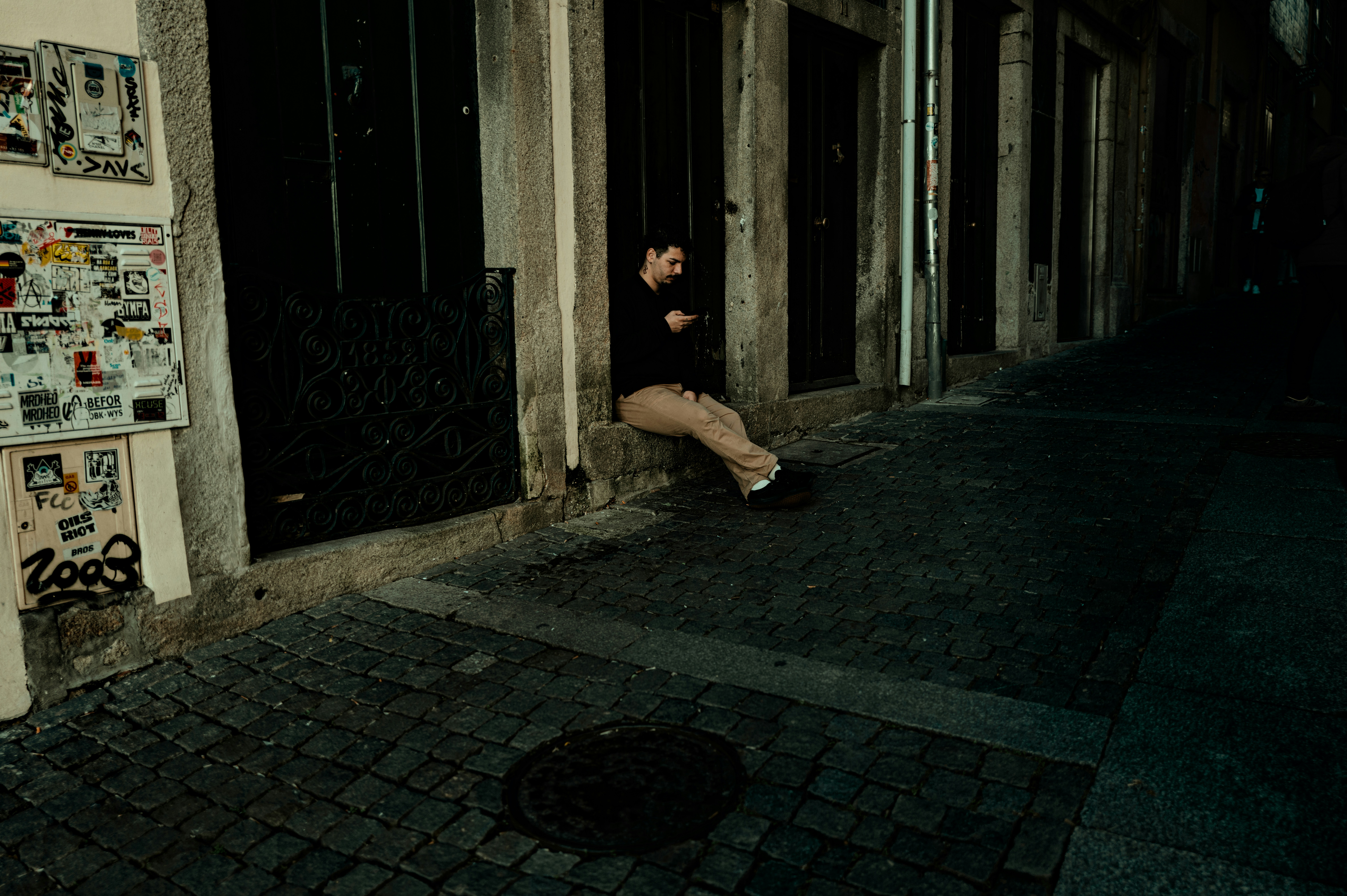 Homme assis sur le rebord devant le bâtiment la nuit