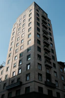 Tall stone building with many windows against blue sky