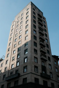 Tall stone building with many windows against blue sky