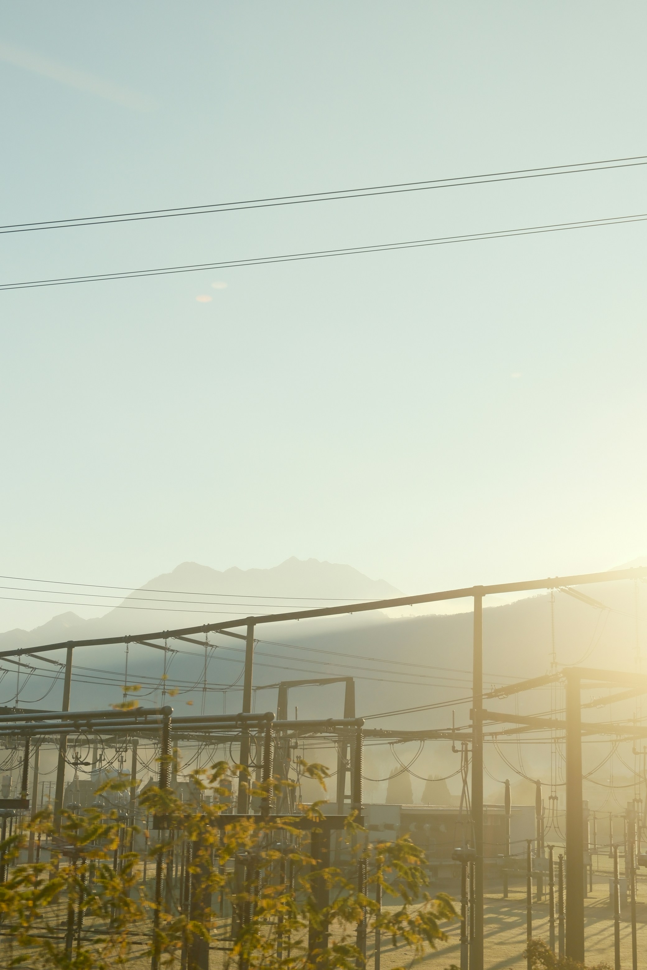 La lumière du soleil illumine une zone clôturée avec des montagnes en arrière-plan.