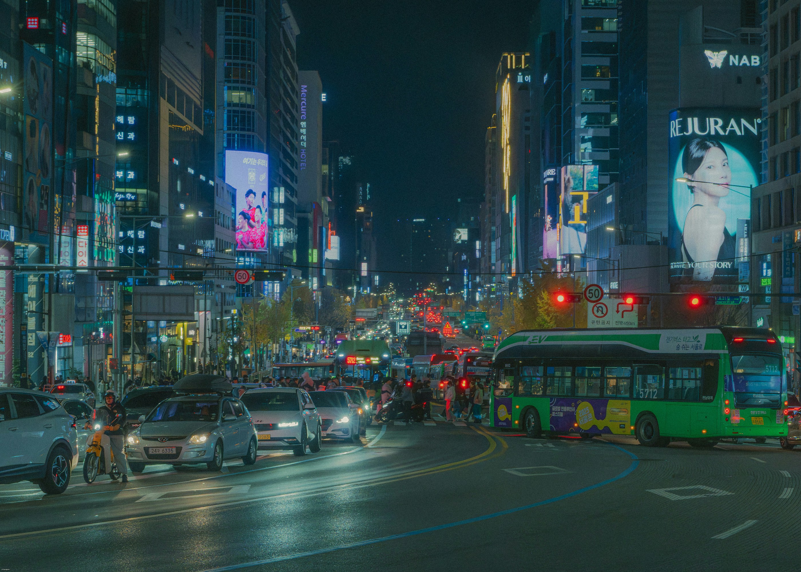 Busy city street at night with traffic and neon lights